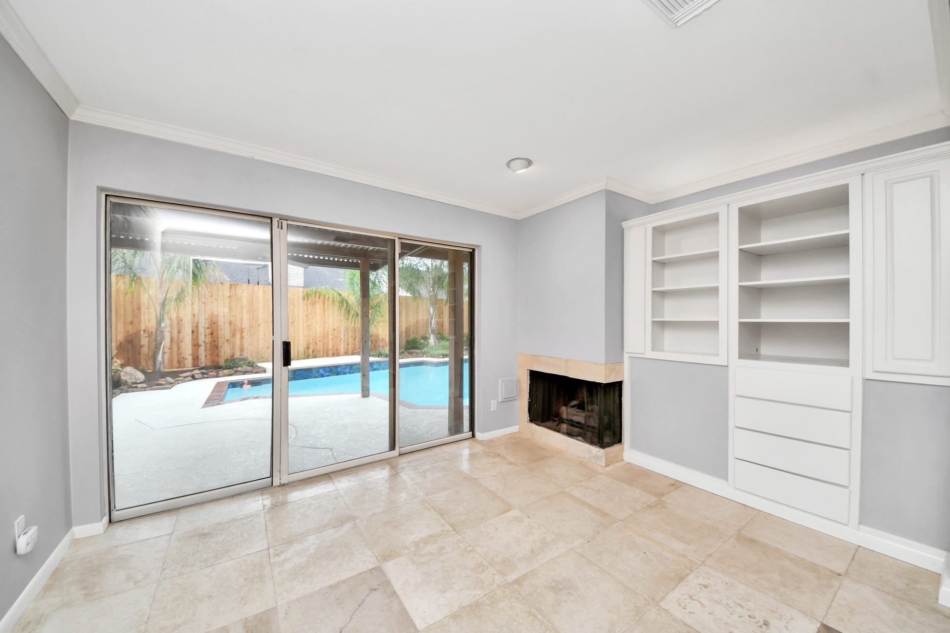 A special extension of the primary suite featuring built-in cabinetry, fireplace and sliding glass doors overlooking the poolideal for a private sitting room or retreat.