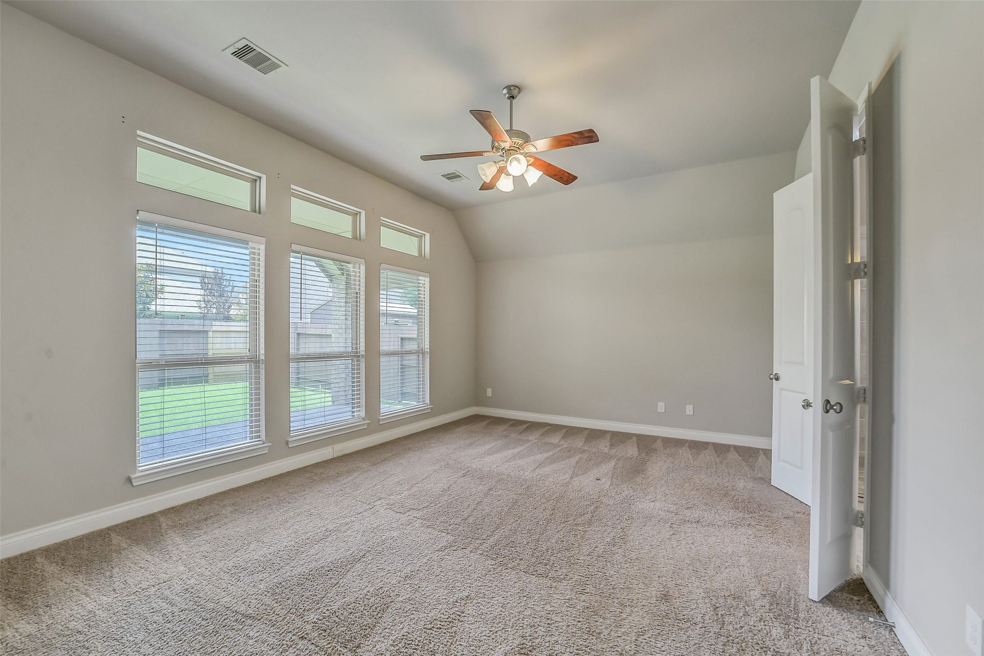 16818 Headwaters Forest Drive, Humble, TX 77346 Spacious primary suite with soaring ceilings, abundant natural light, plush carpet, and large windows overlooking the backyard.