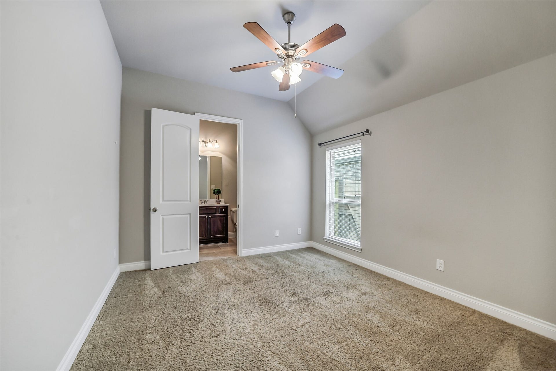 16818 Headwaters Forest Drive, Humble, TX 77346 Secondary bedroom #1 with plush carpet, ceiling fan, abundant natural light, and convenient access to a full bathroom.