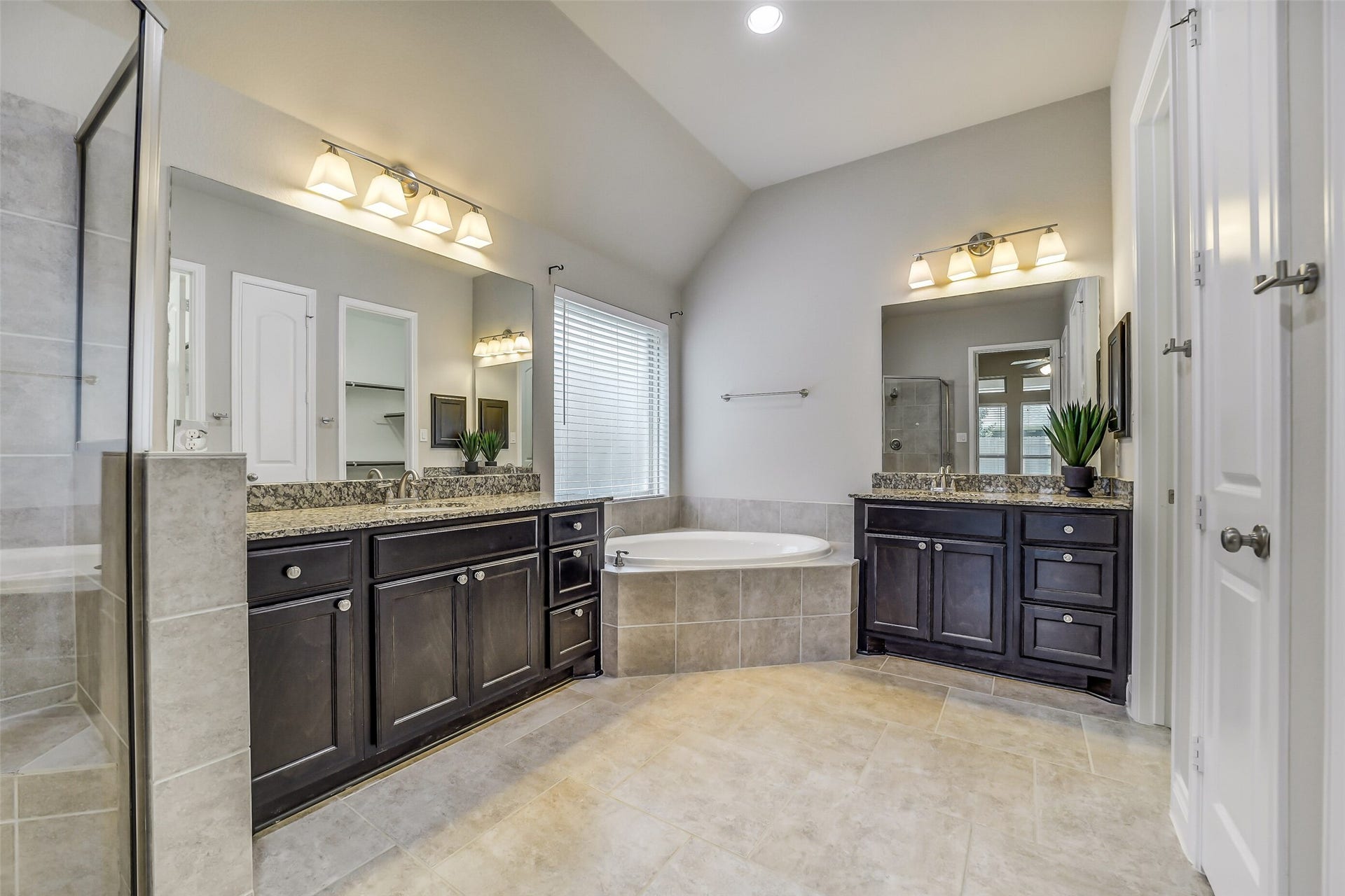 16818 Headwaters Forest Drive, Humble, TX 77346 Luxurious primary bath featuring dual vanities, granite countertops, soaking tub, separate walk-in shower, and generous space for everyday comfort.