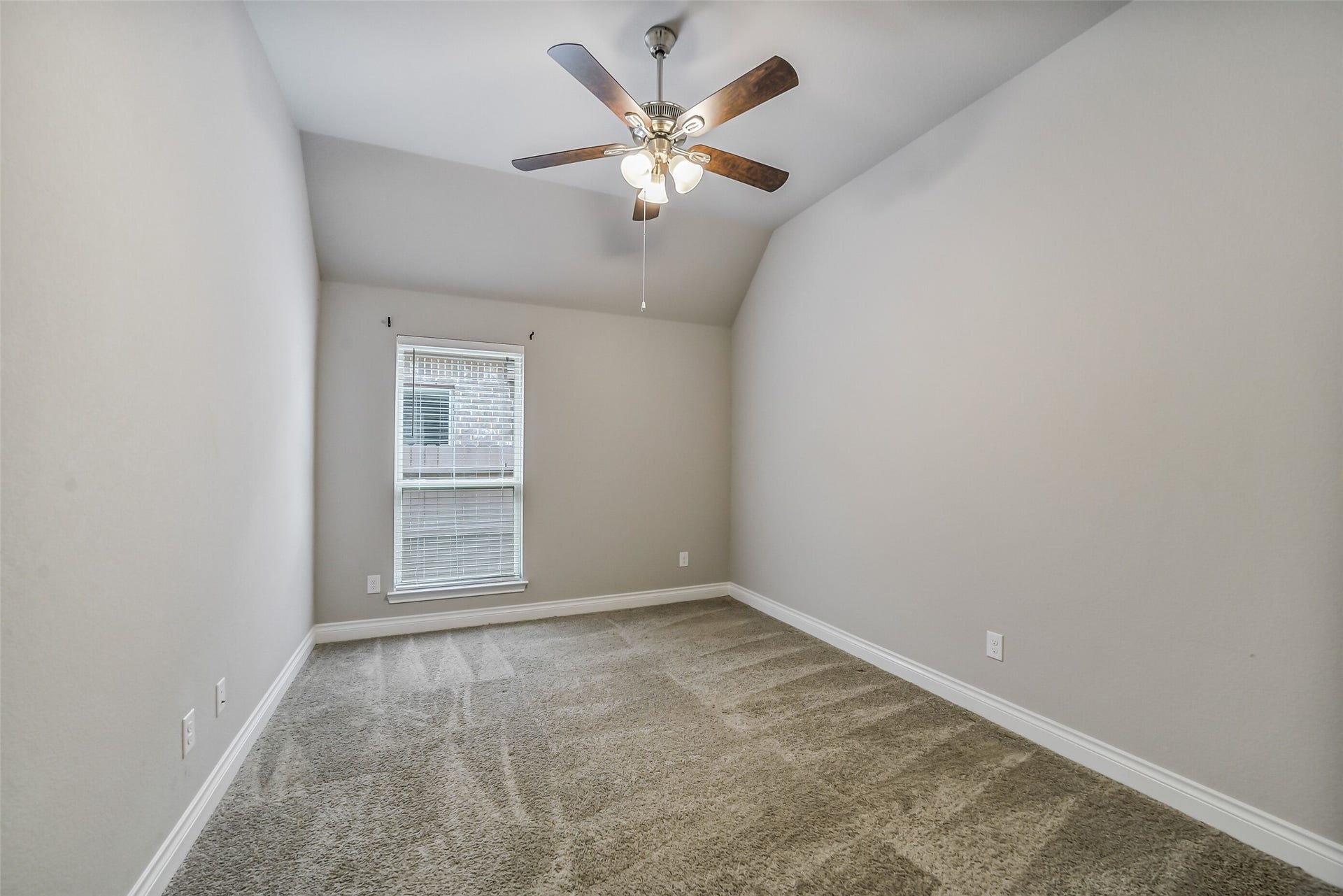16818 Headwaters Forest Drive, Humble, TX 77346 Comfortable secondary bedroom with vaulted ceiling, plush carpet, ceiling fan, and natural light.