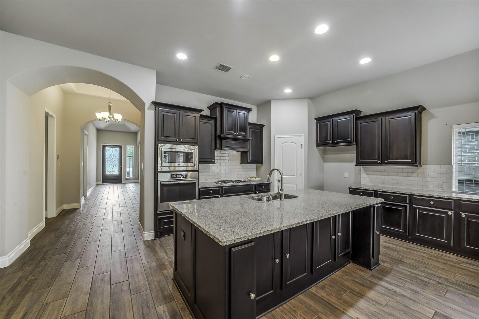 16818 Headwaters Forest Drive, Humble, TX 77346 Gourmet kitchen featuring a large center island with seating, abundant cabinetry, granite countertops, stainless steel appliances, and generous prep space.