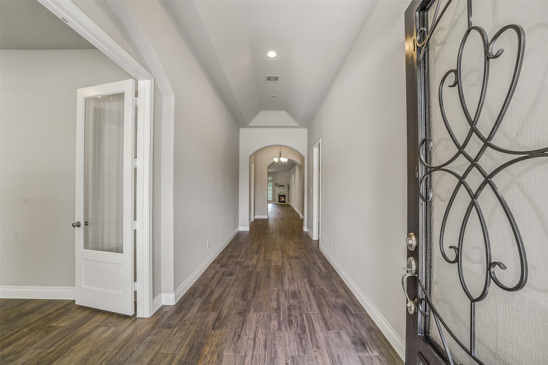 16818 Headwaters Forest Drive, Humble, TX 77346 Step inside to a welcoming foyer featuring soaring ceilings, wood-look tile flooring, and a long hallway leading to the open-concept living spaces.