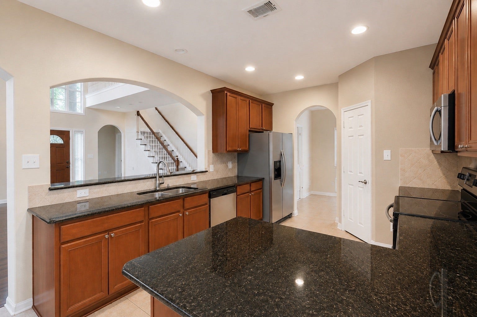 14907 E Lime Blossom Court, Cypress, TX 77433 he kitchen is designed with both function and style in mind, featuring rich wooden cabinetry and striking black granite countertops.