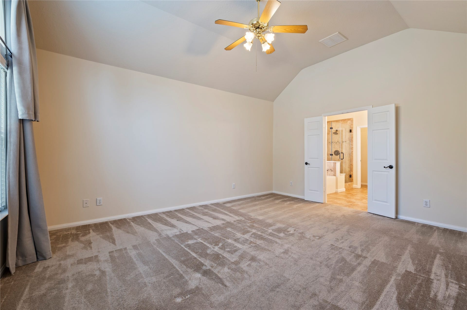 Primary bedroom with high ceilings and ensuite bathroom