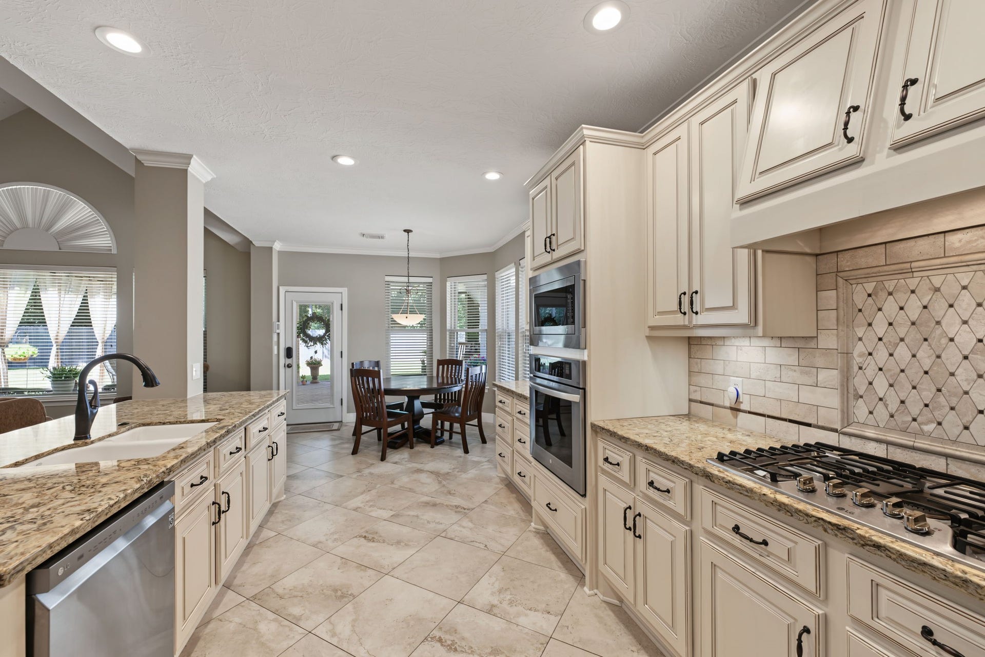 4807 Stonecrop Court, Houston, TX 77345 5-burner gas range with vent hood tucked underneath the top cabinets.