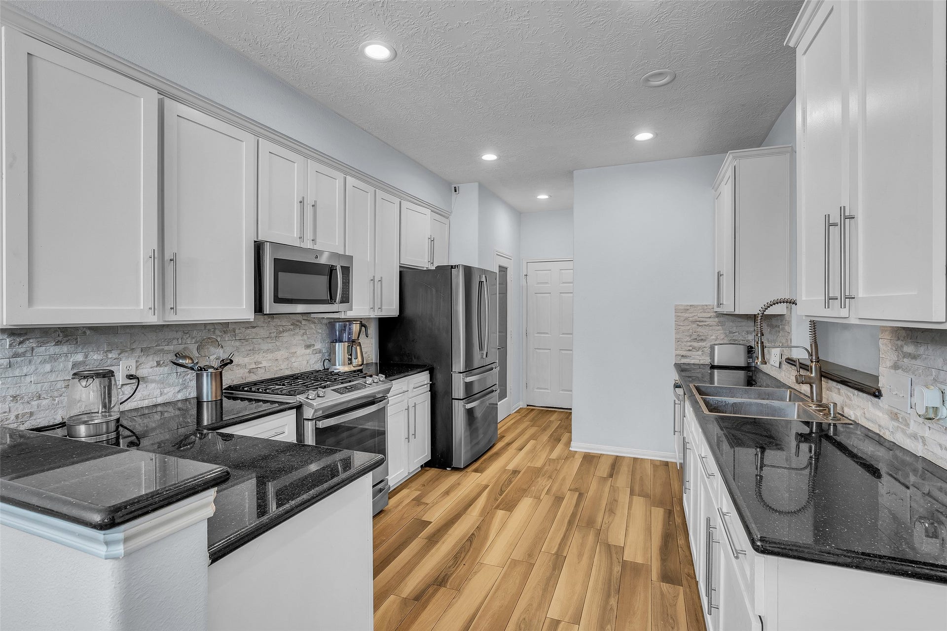 1408 S Friendswood Drive, #1301, Friendswood, TX 77546 Stunning updated kitchen shines with a new backsplash and refinished cabinets.