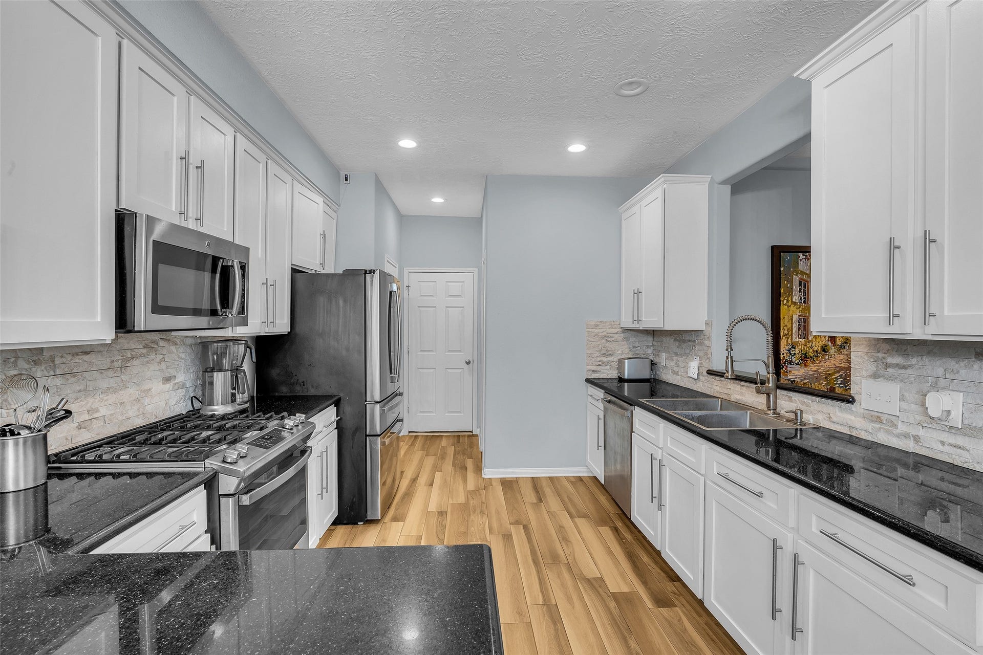 1408 S Friendswood Drive, #1301, Friendswood, TX 77546 Stainless steel appliances and granite counters set the stage for the cooking show.