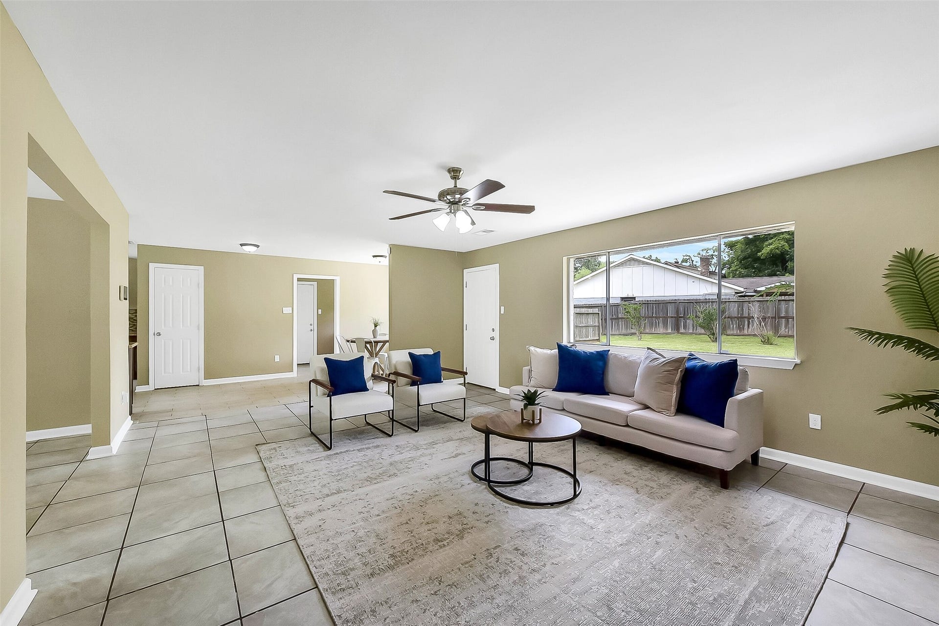15503 Wandering Trail, Friendswood, TX 77546 Continue into this spacious family room with a cozy brick fireplace, large windows for natural light, neutral tones, and easy-care tile flooring that flows into the dining area.
