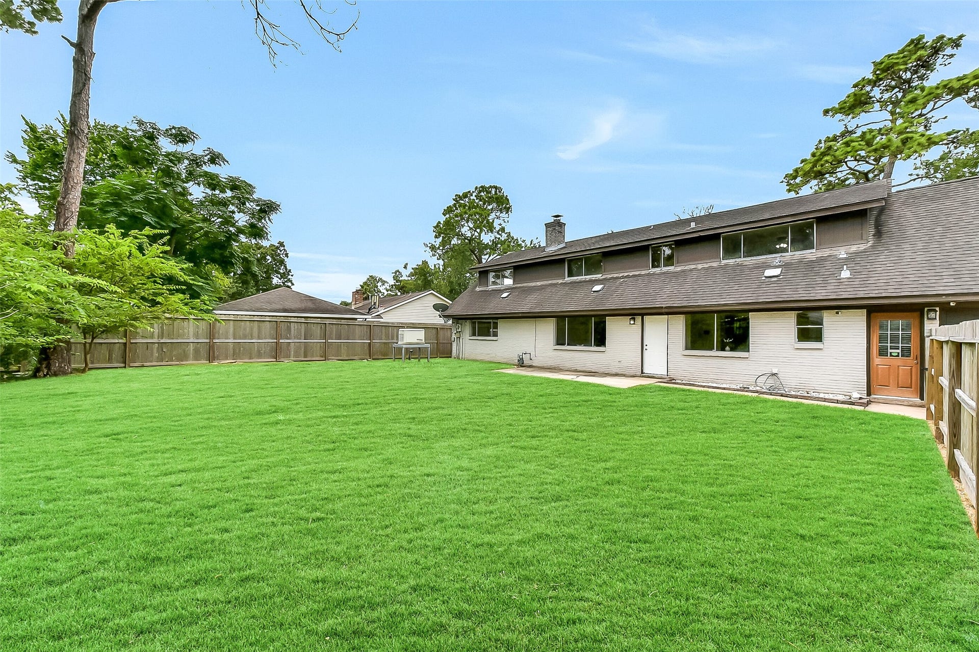 15503 Wandering Trail, Friendswood, TX 77546 Expansive fenced backyard with a concrete patio area, mature trees, and plenty of open green spaceperfect for outdoor living, gardening, or entertaining. Also includes a whole-house Generac generator for peace of mind.