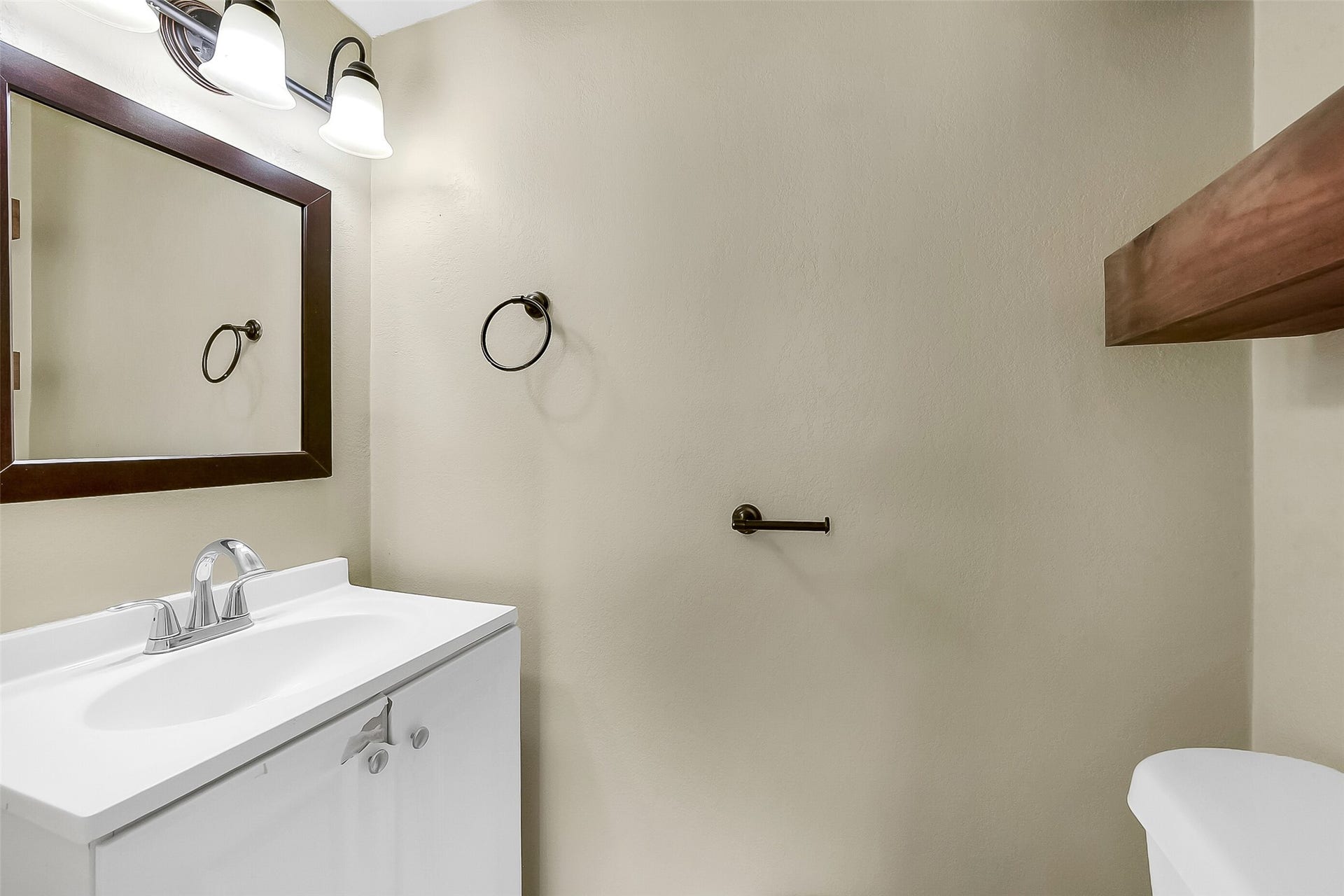 15503 Wandering Trail, Friendswood, TX 77546 Convenient first-floor half bath with updated vanity, framed mirror, and modern light fixture, offering both style and function for guests.