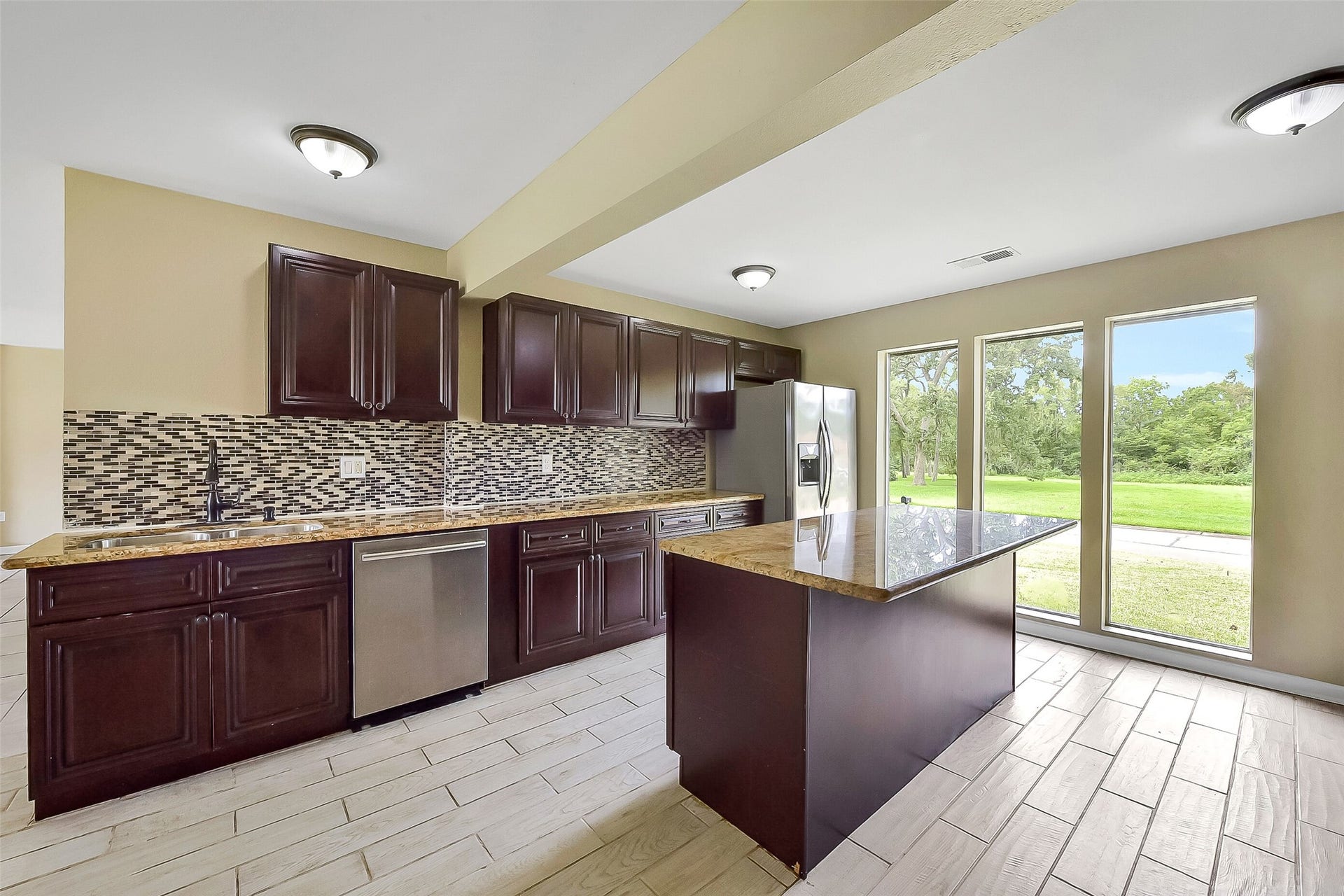 15503 Wandering Trail, Friendswood, TX 77546 From the kitchen, enjoy floor-to-ceiling windows that fill the space with natural light and showcase serene outdoor views.