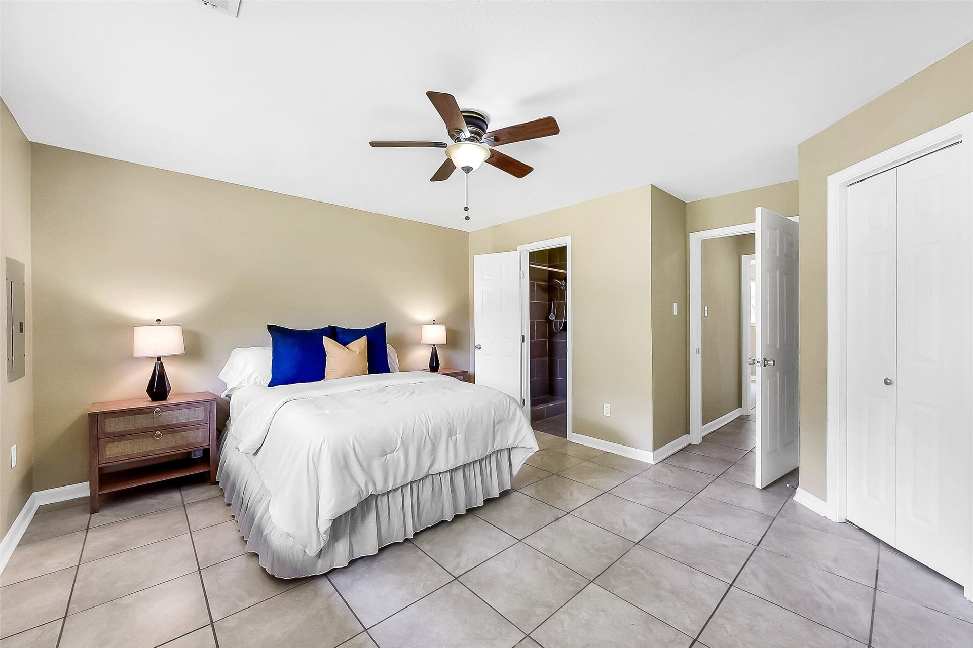 15503 Wandering Trail, Friendswood, TX 77546 This first-floor primary suite offers a peaceful retreat with neutral tones, tile flooring, a ceiling fan, and a large window that fills the room with natural light. An en-suite bath provides added privacy and convenience.