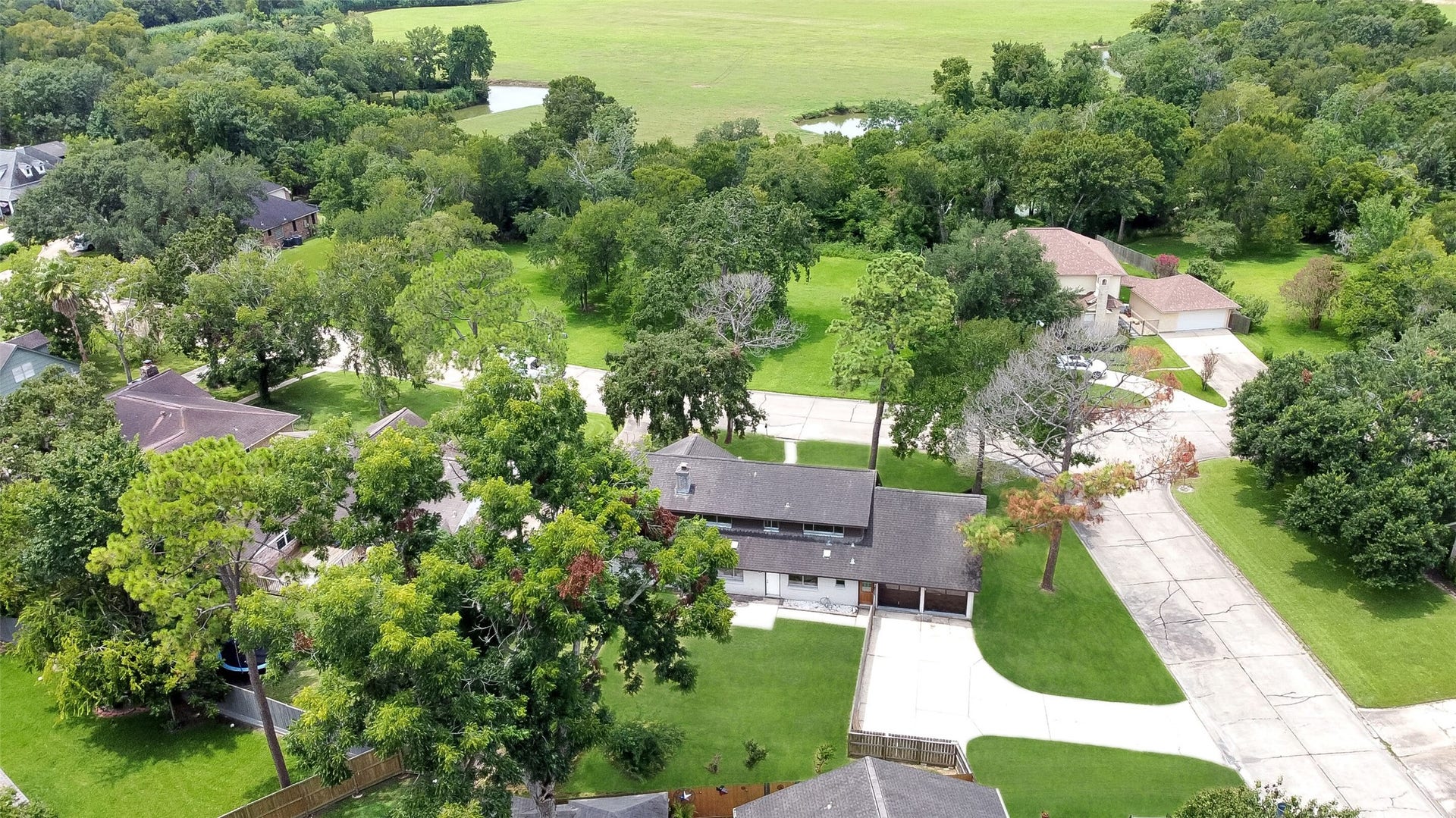 15503 Wandering Trail, Friendswood, TX 77546 Aerial views showcase this spacious 2-story home on a large corner lot with mature trees, fenced backyard, and prime Wedgewood Village location in CCISD.