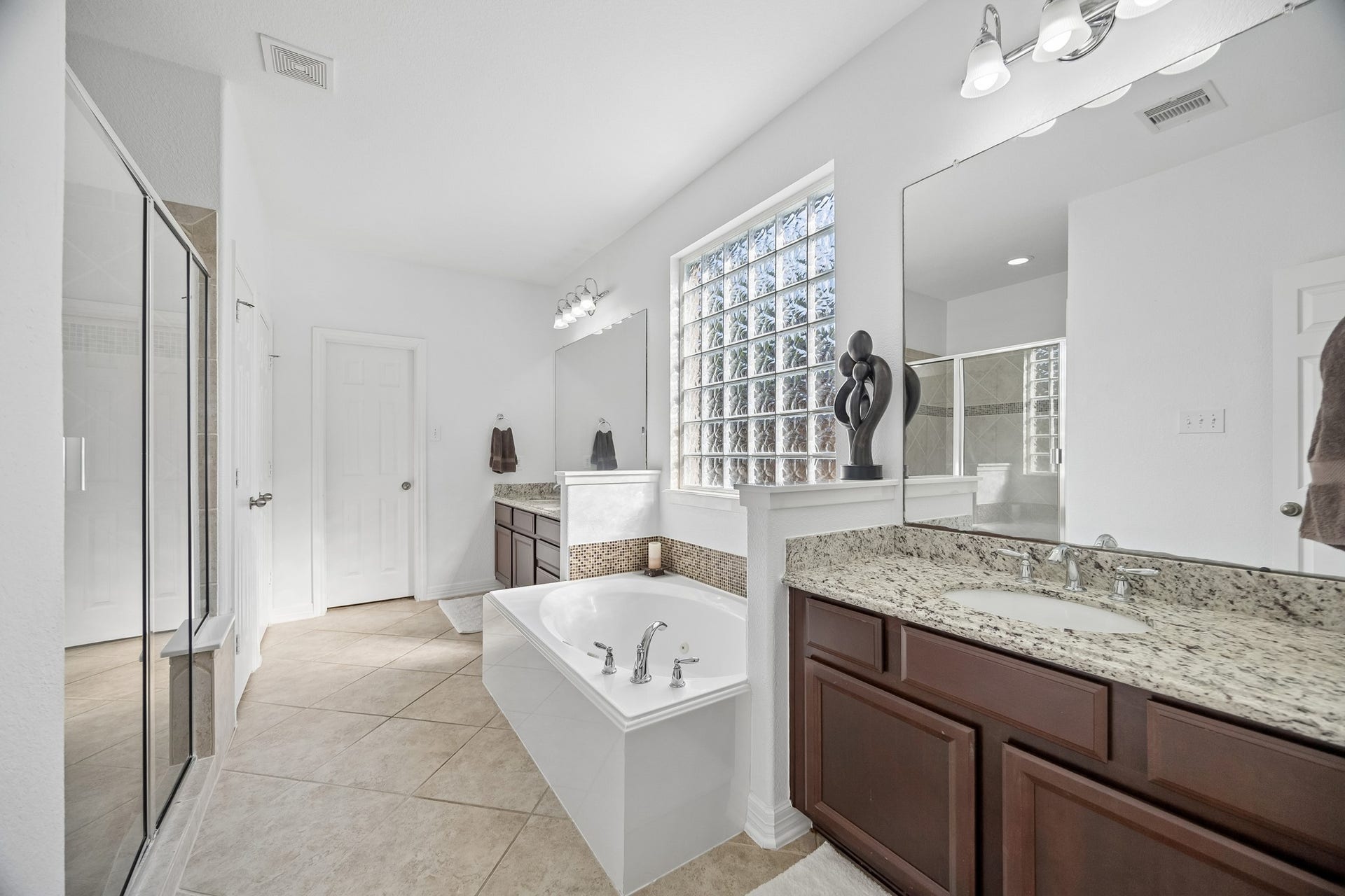 3102 London Lane, Missouri City, TX 77459 Split vanities and an oversized glass framed shower are a few of the primary bath features. The door on the opposite wall is the spacious closet.