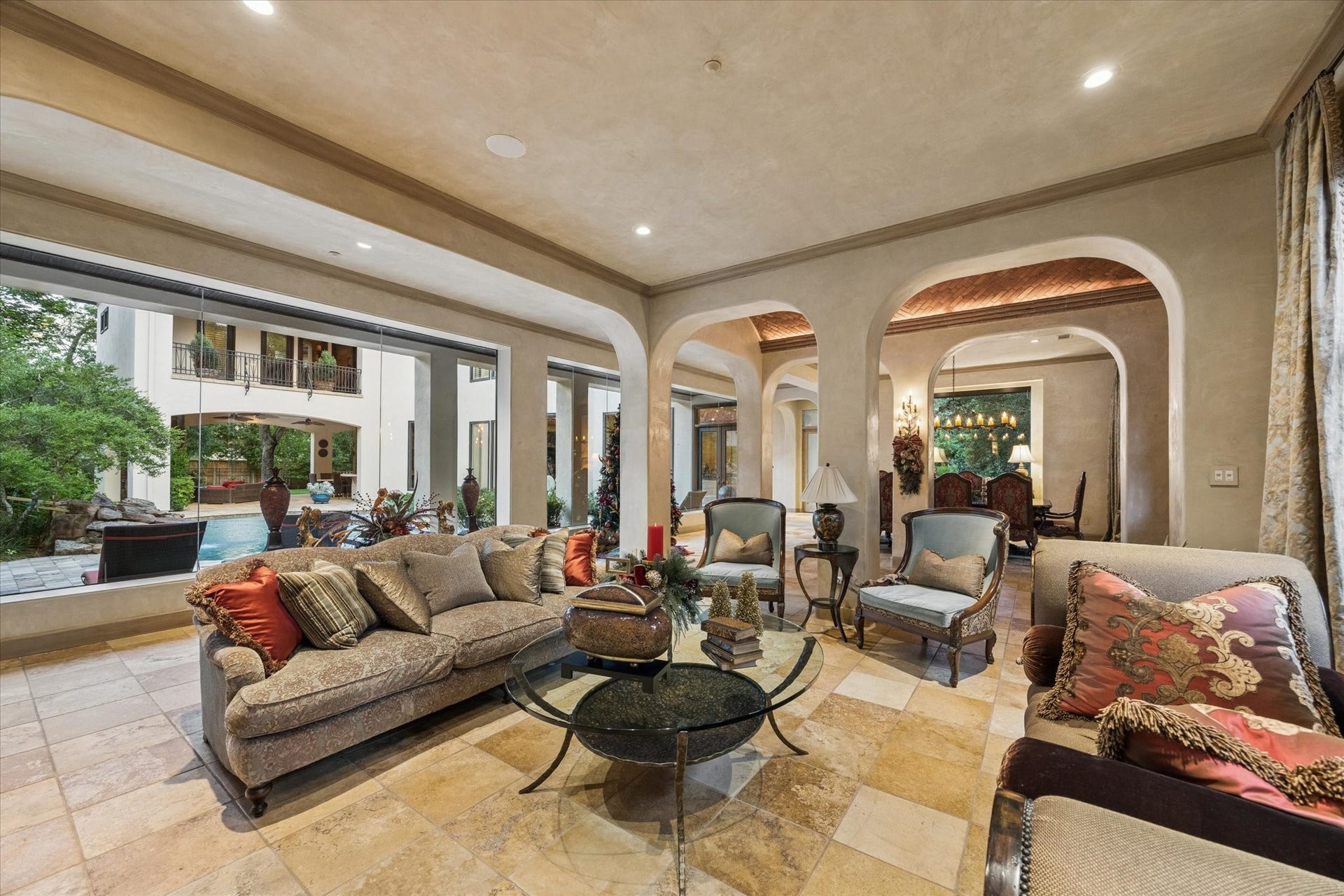 2 Lacewood Lane, Piney Point Village, TX 77024 Additional view highlighting the homes graceful arches, open sightlines, and connection to the poolside outdoor living areas.