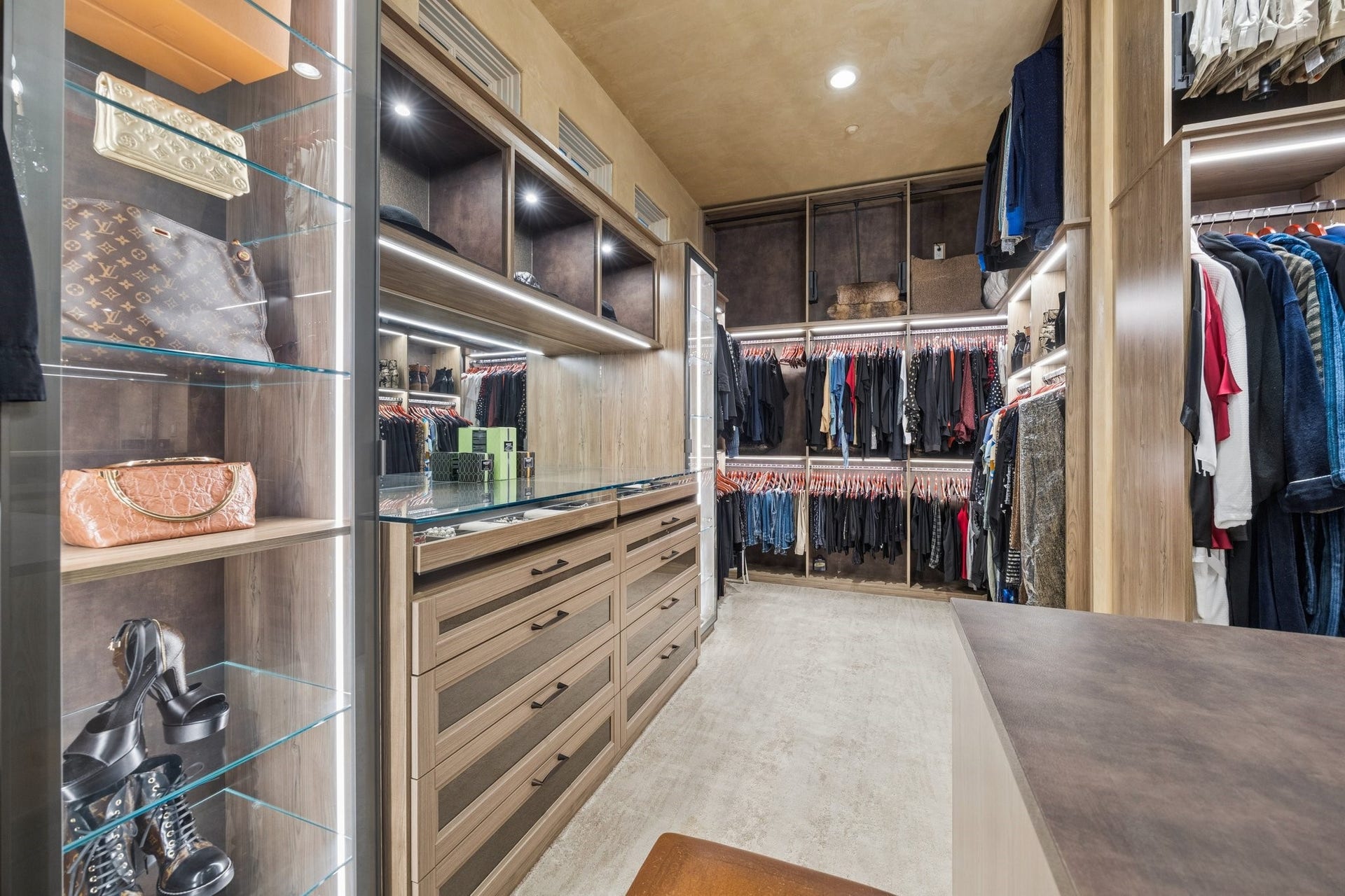 2 Lacewood Lane, Piney Point Village, TX 77024 Additional owners closet view showcasing illuminated display cabinetry, extensive hanging space, and custom boutique-style storage.