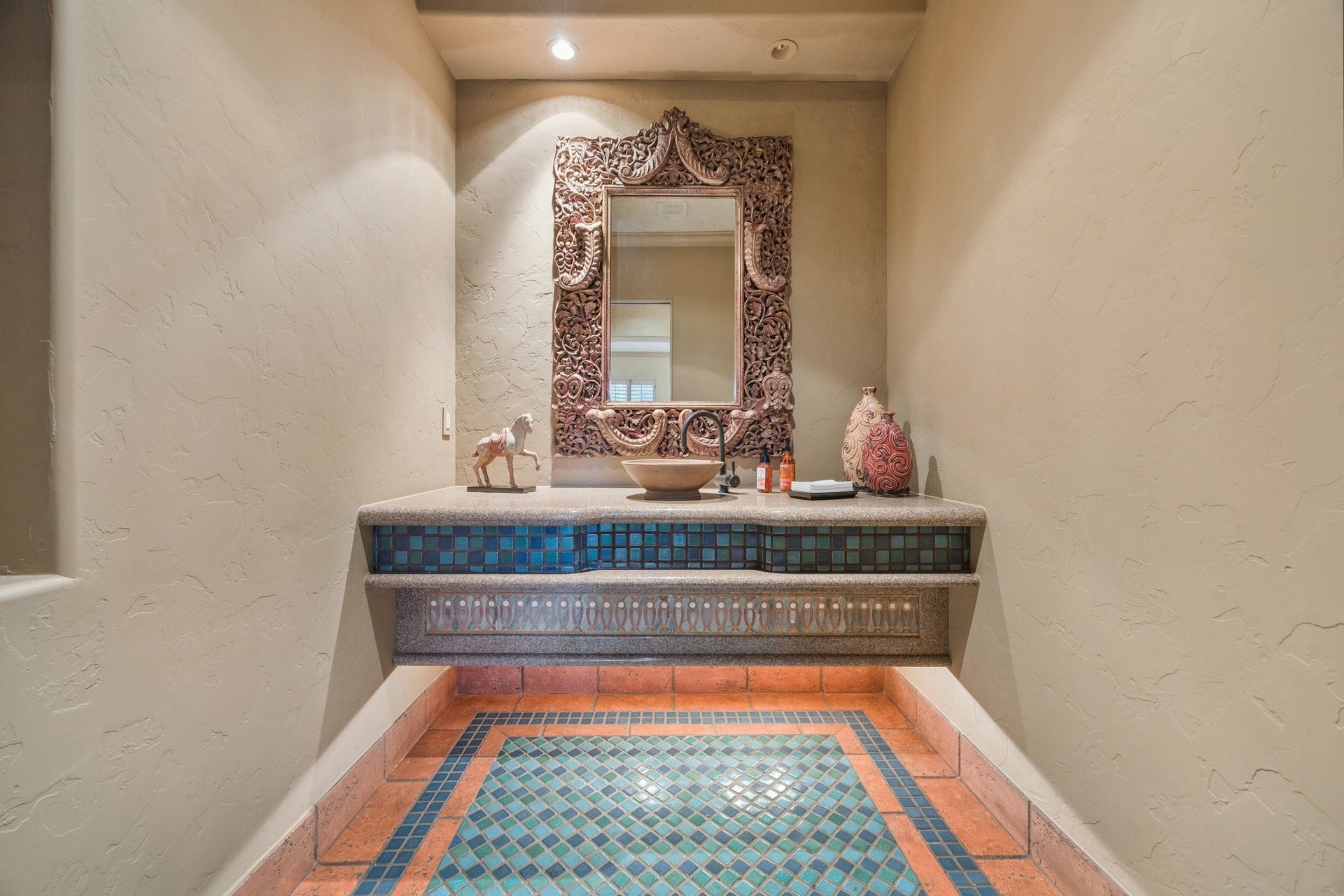 2 Lacewood Lane, Piney Point Village, TX 77024 Upstairs powder room featuring a custom vanity, colorful tile detailing, and an ornate statement mirror.