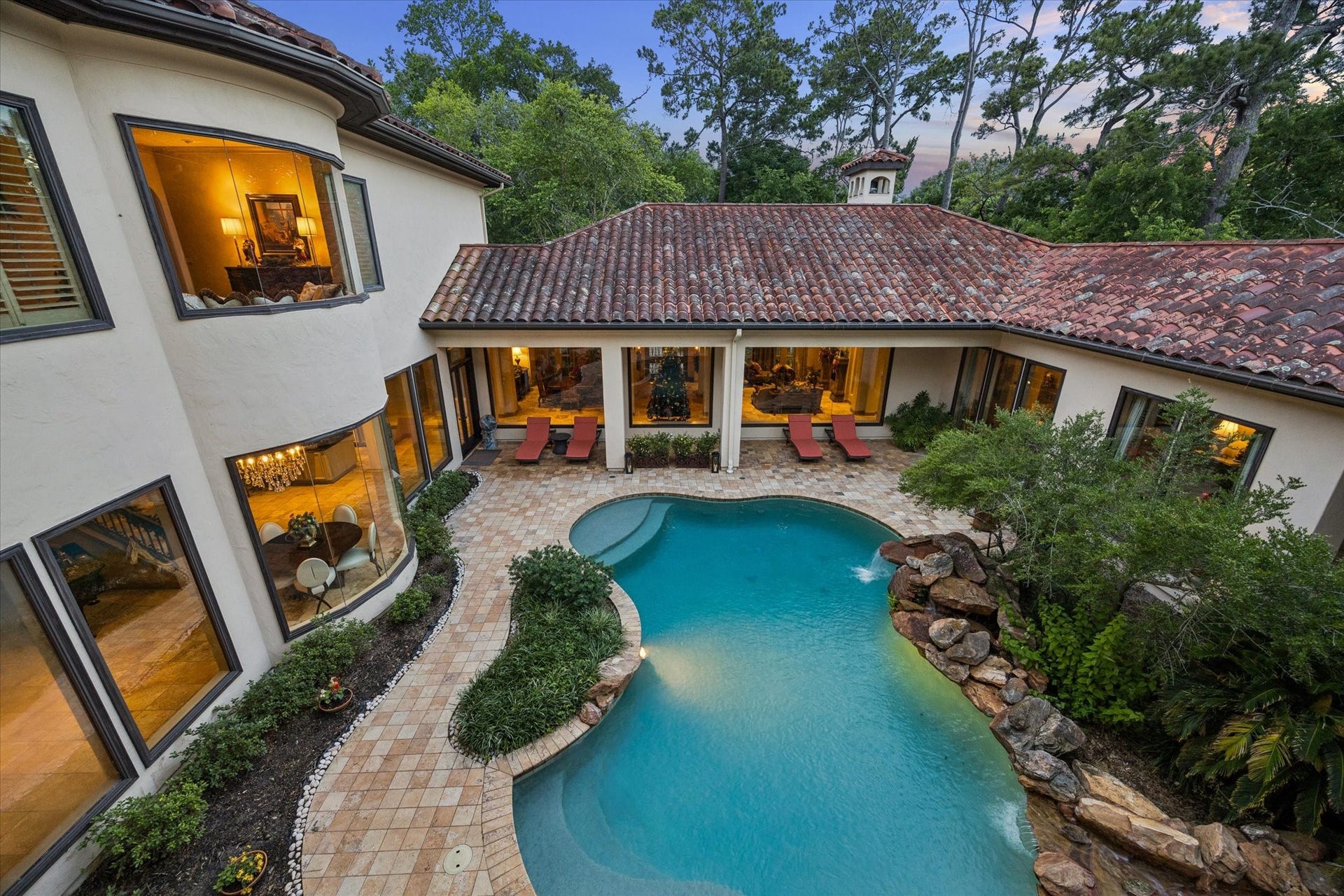 2 Lacewood Lane, Piney Point Village, TX 77024 View from the upstairs balcony showcasing the resort-style pool, private courtyard, and lush treetop surroundings.