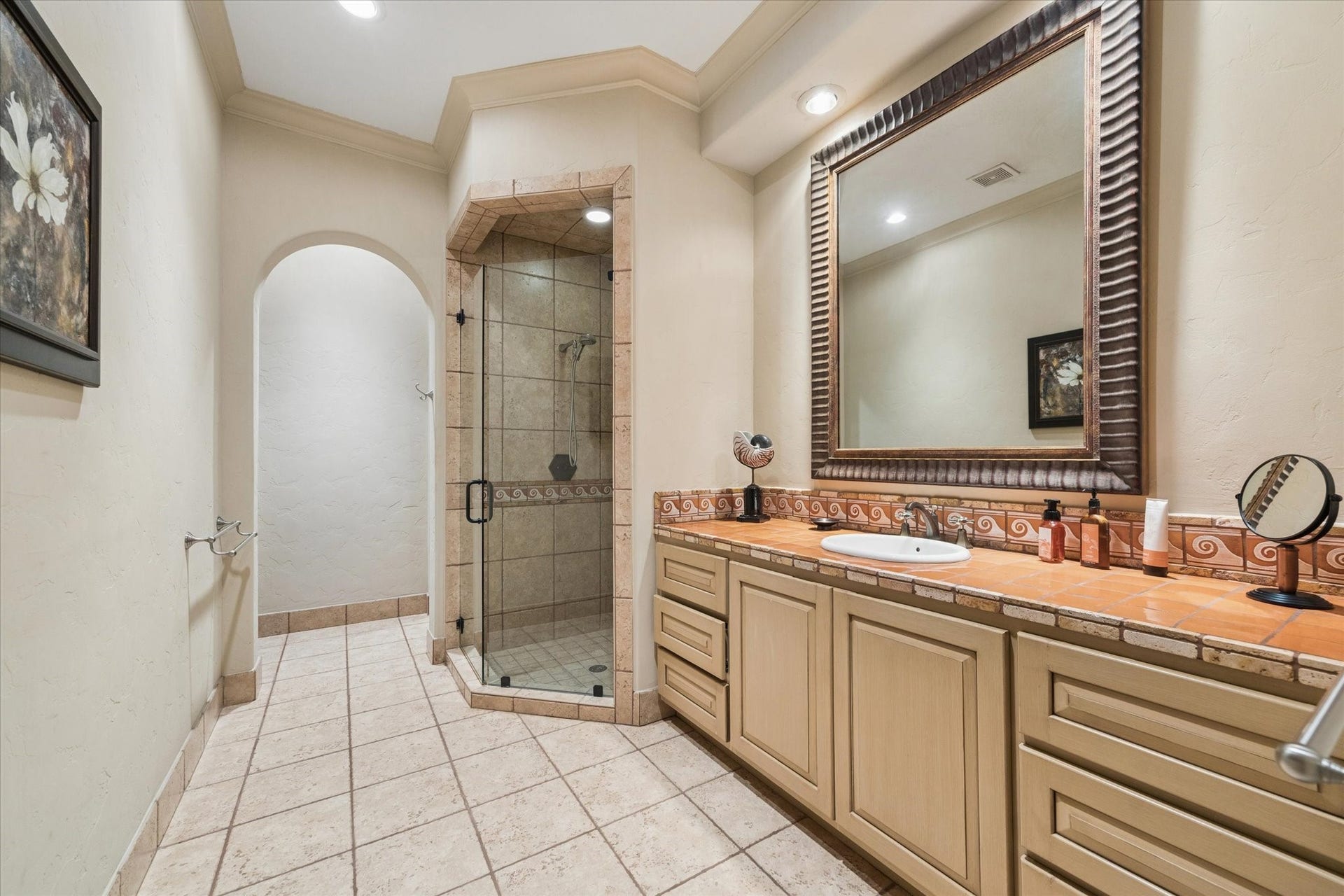 2 Lacewood Lane, Piney Point Village, TX 77024 Private en-suite bath featuring a custom vanity, walk-in shower, and warm Mediterranean-inspired tile detail.
