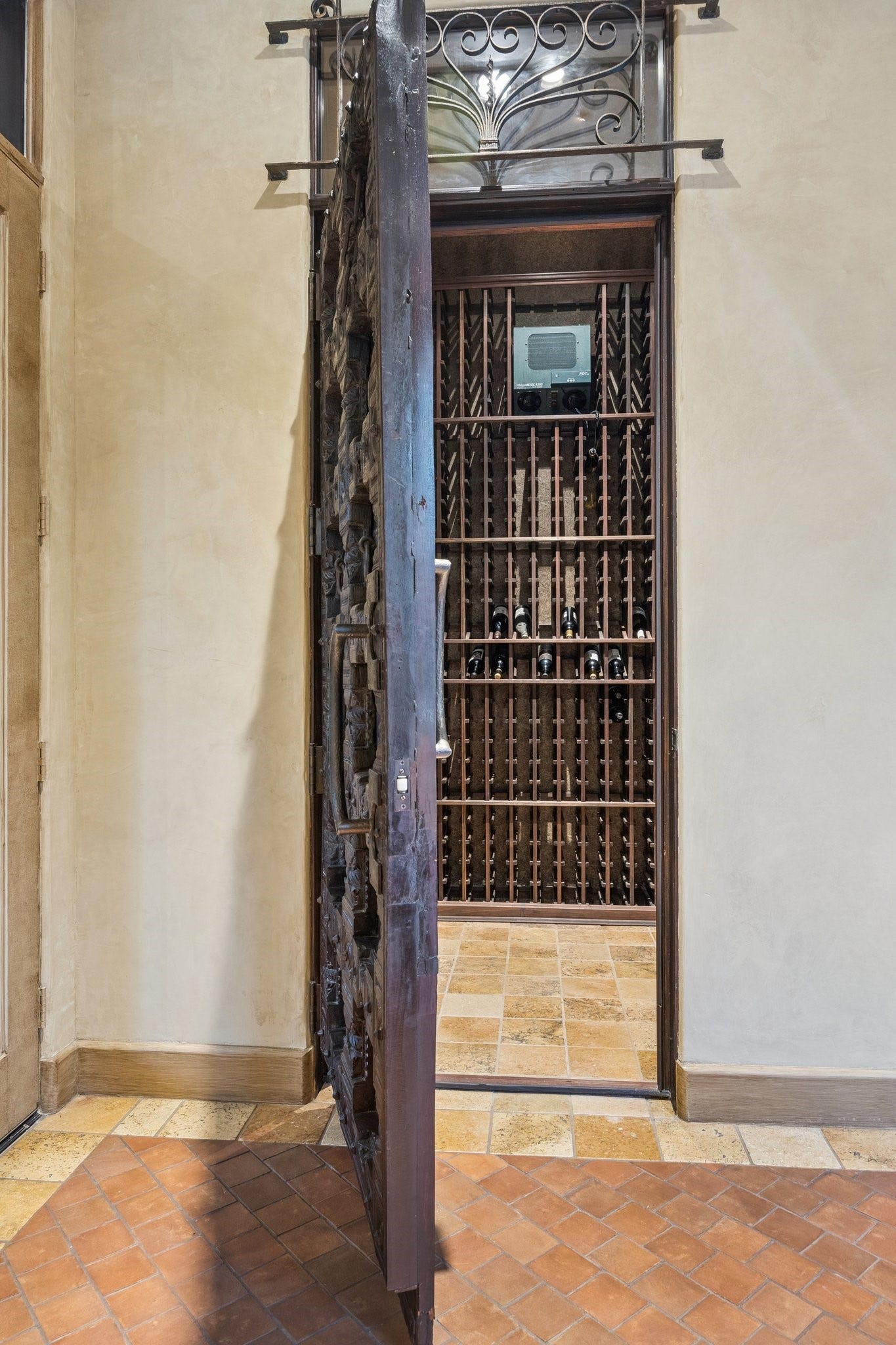2 Lacewood Lane, Piney Point Village, TX 77024 Distinctive wine cellar with custom storage and a Distinctive wine cellar with custom storage and a beautifully carved entry door.