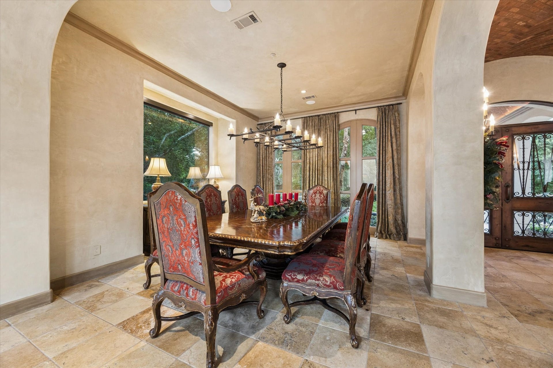 2 Lacewood Lane, Piney Point Village, TX 77024 Refined formal dining space near the entry, framed by Mediterranean arches, warm stone flooring, and a timeless estate feel.