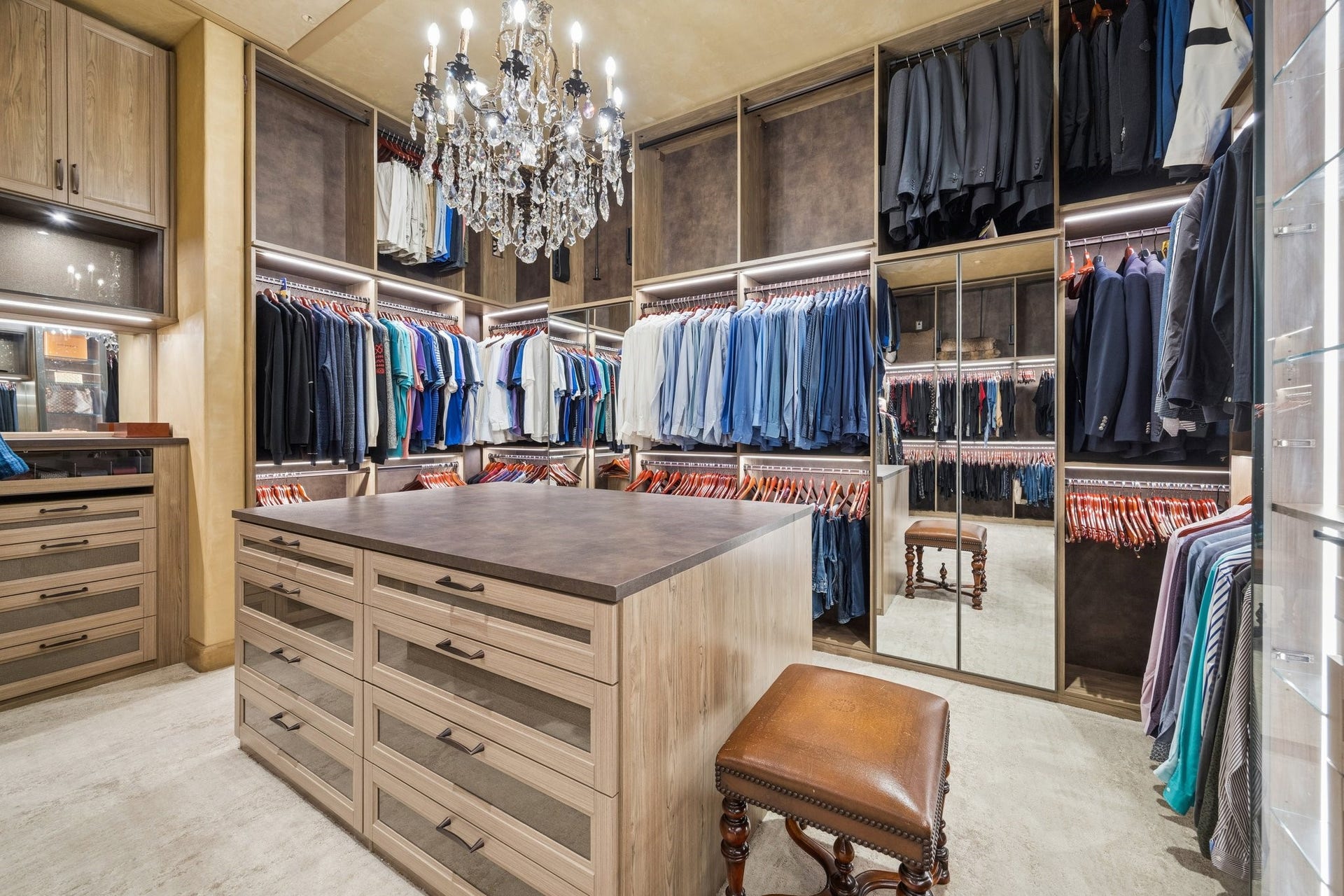 2 Lacewood Lane, Piney Point Village, TX 77024 Custom-designed owners closet with boutique-style display, center island, illuminated storage, and chandelier detail.