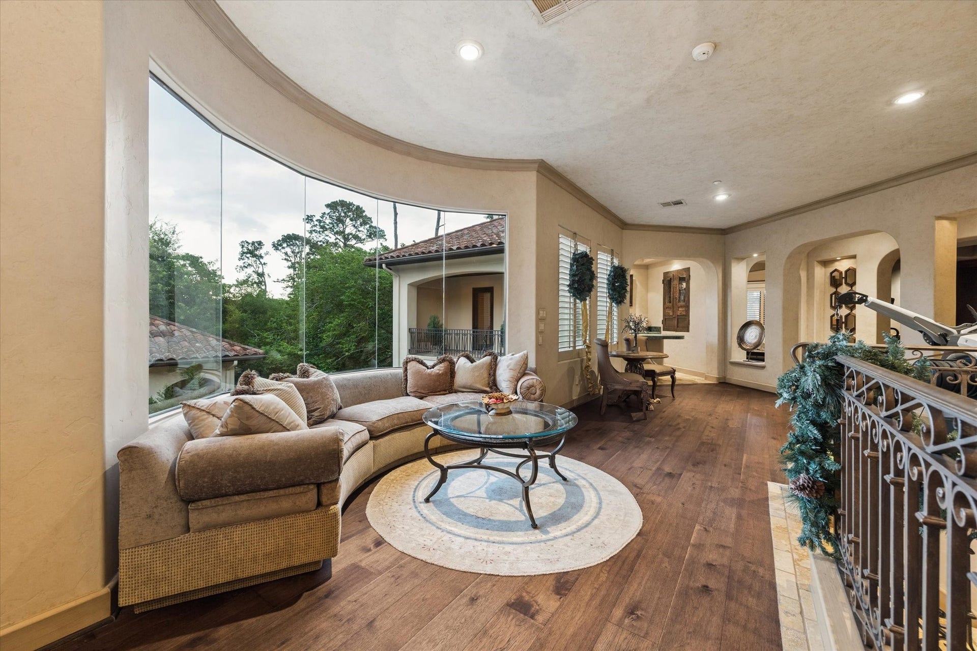 2 Lacewood Lane, Piney Point Village, TX 77024 Upstairs landing with sitting area, rich wood flooring, and expansive windows overlooking the private grounds.