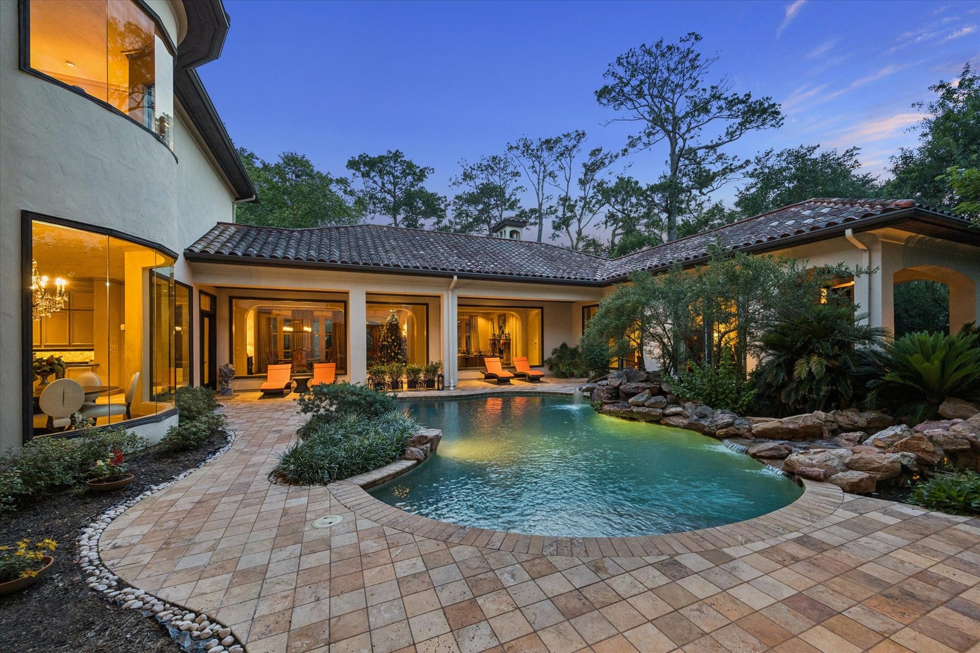 2 Lacewood Lane, Piney Point Village, TX 77024 Expansive courtyard view highlighting the resort-style pool, waterfall feature, and the homes seamless entertaining spaces oriented around the private pool courtyard.