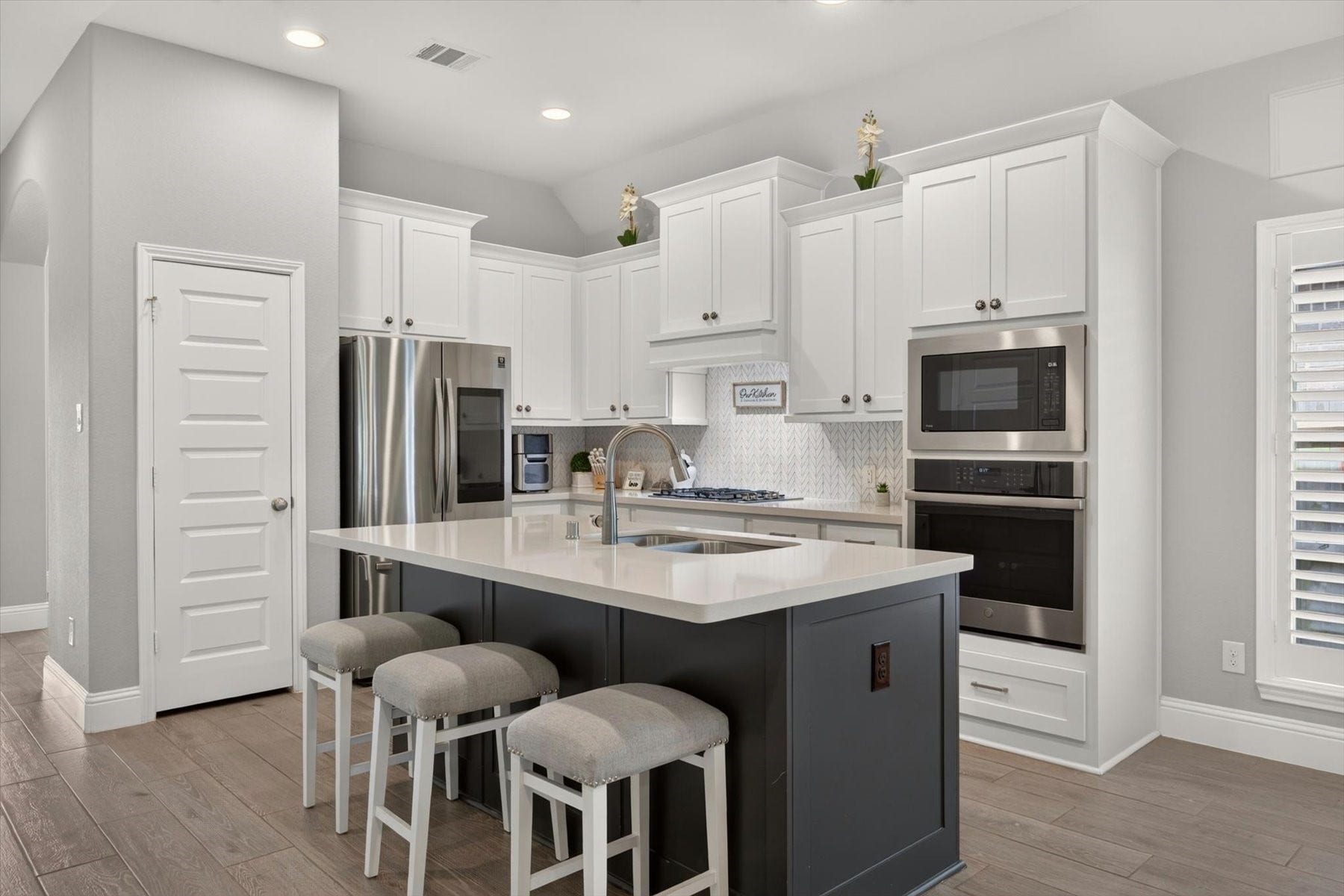 23026 Needlegrass Road, Katy, TX 77493 Island kitchen with granite countertops, gas cooking, and breakfast seating.
