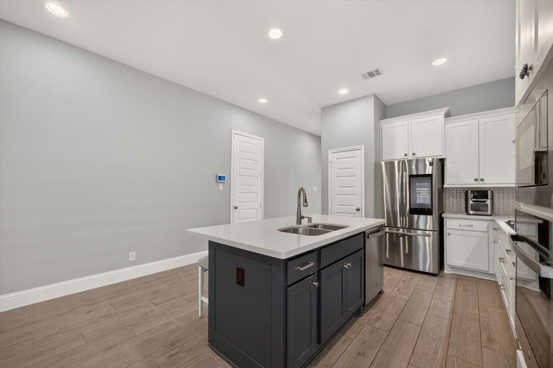 23026 Needlegrass Road, Katy, TX 77493 Expansive kitchen with convenient island and abundant prep space. Ceramic wood-look tile throughout main spaces.