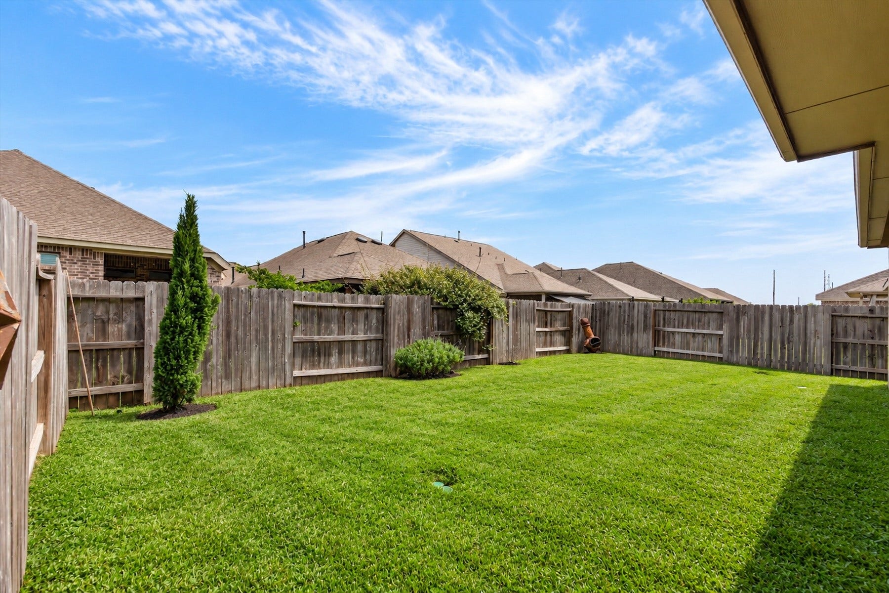 23026 Needlegrass Road, Katy, TX 77493 Fully fenced backyard with lush green lawn and plenty of play space.