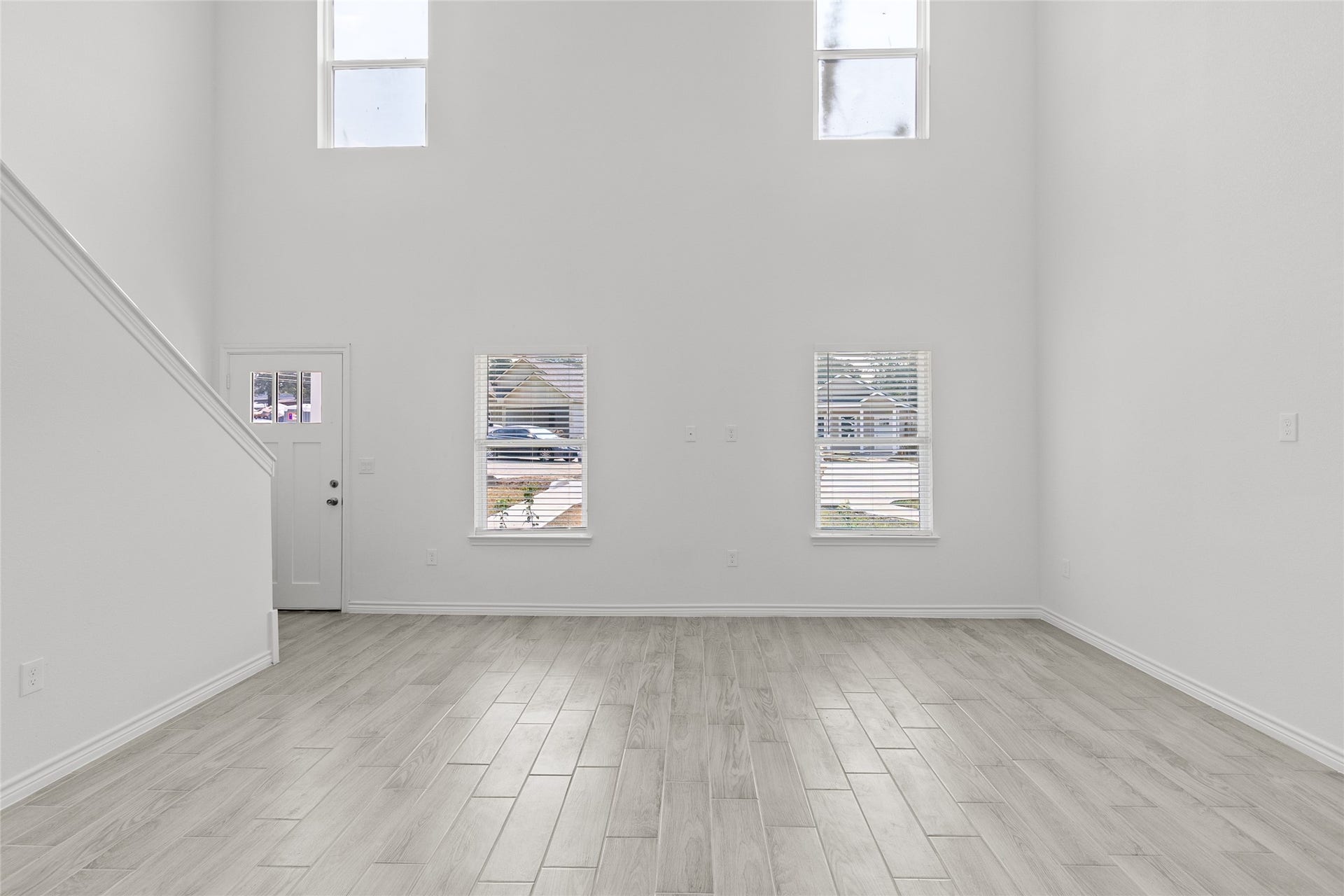 760 Juneau Court, Montgomery, TX 77316 This is a bright, spacious room with high ceilings, large windows, and modern wood-look flooring, featuring a staircase leading to the upper level.