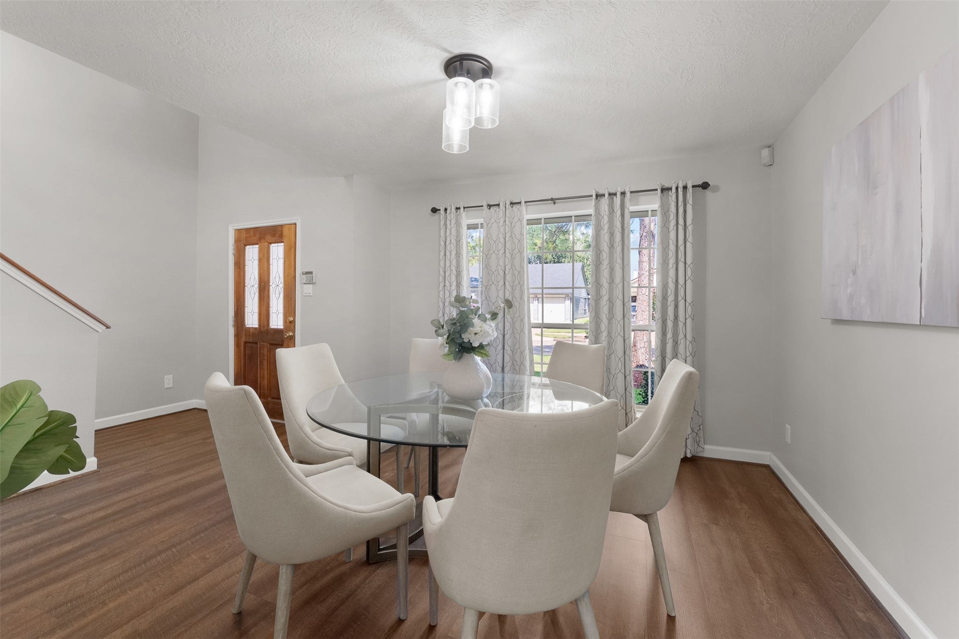 1118 Wentworth Drive, Pearland, TX 77584 Positioned off the entry, this bright dining area displays rich wood-look floors and neutral walls with high ceilings. Large gridded windows frame neighborhood views, creating a welcoming backdrop for everyday meals and social gatherings.
