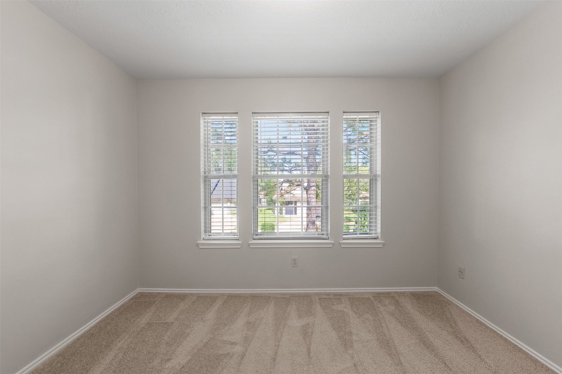 1118 Wentworth Drive, Pearland, TX 77584 Soft carpet flooring and freshly painted walls frame a triple window that bathes this secondary bedroom in light.