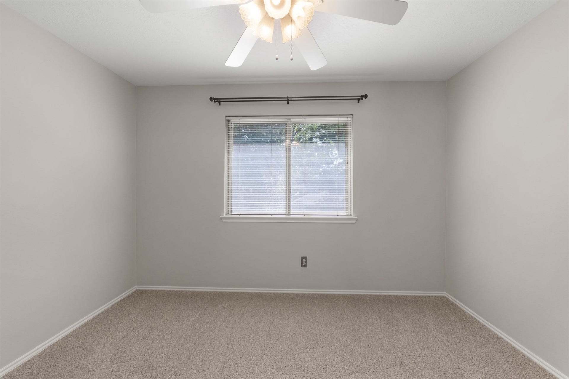 1118 Wentworth Drive, Pearland, TX 77584 Soft carpet flooring and neutral walls define this secondary bedroom, anchored by a central window framed with blinds. A classic ceiling fan provides steady breeze and illumination in this versatile space.