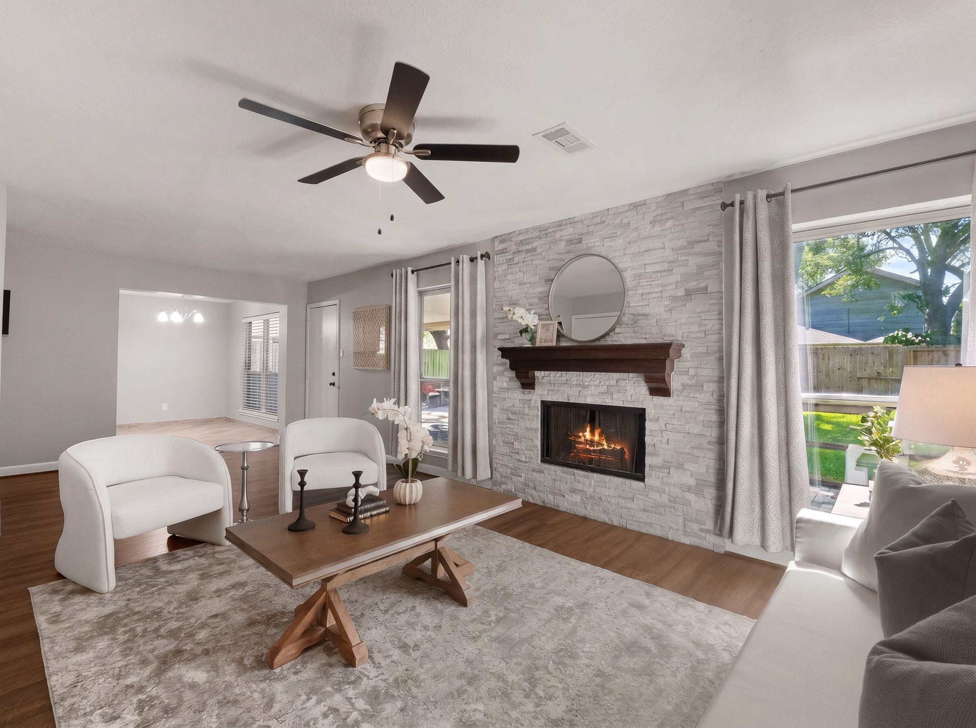 1118 Wentworth Drive, Pearland, TX 77584 A focal stone stack gas fireplace framed by rich wood mantel accents anchors this open living area. Expansive windows frame green backyard views, creating a seamless connection to the nearby dining space.