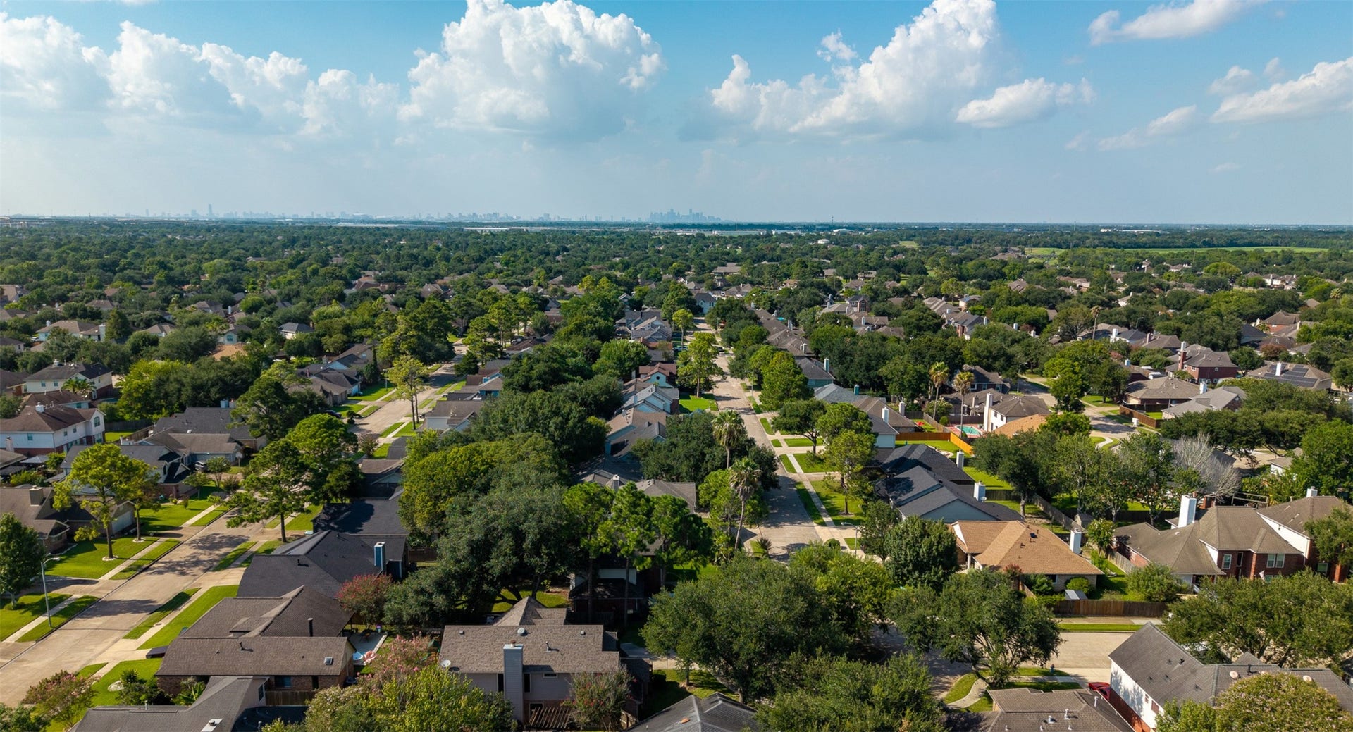 1118 Wentworth Drive, Pearland, TX 77584 An aerial view captures the vast, tree-canopied neighborhood stretching toward the distant Houston skyline. Convenient access to major thoroughfares ensures a quick commute to the Medical Center alongside proximity to top retail and dining destinations.