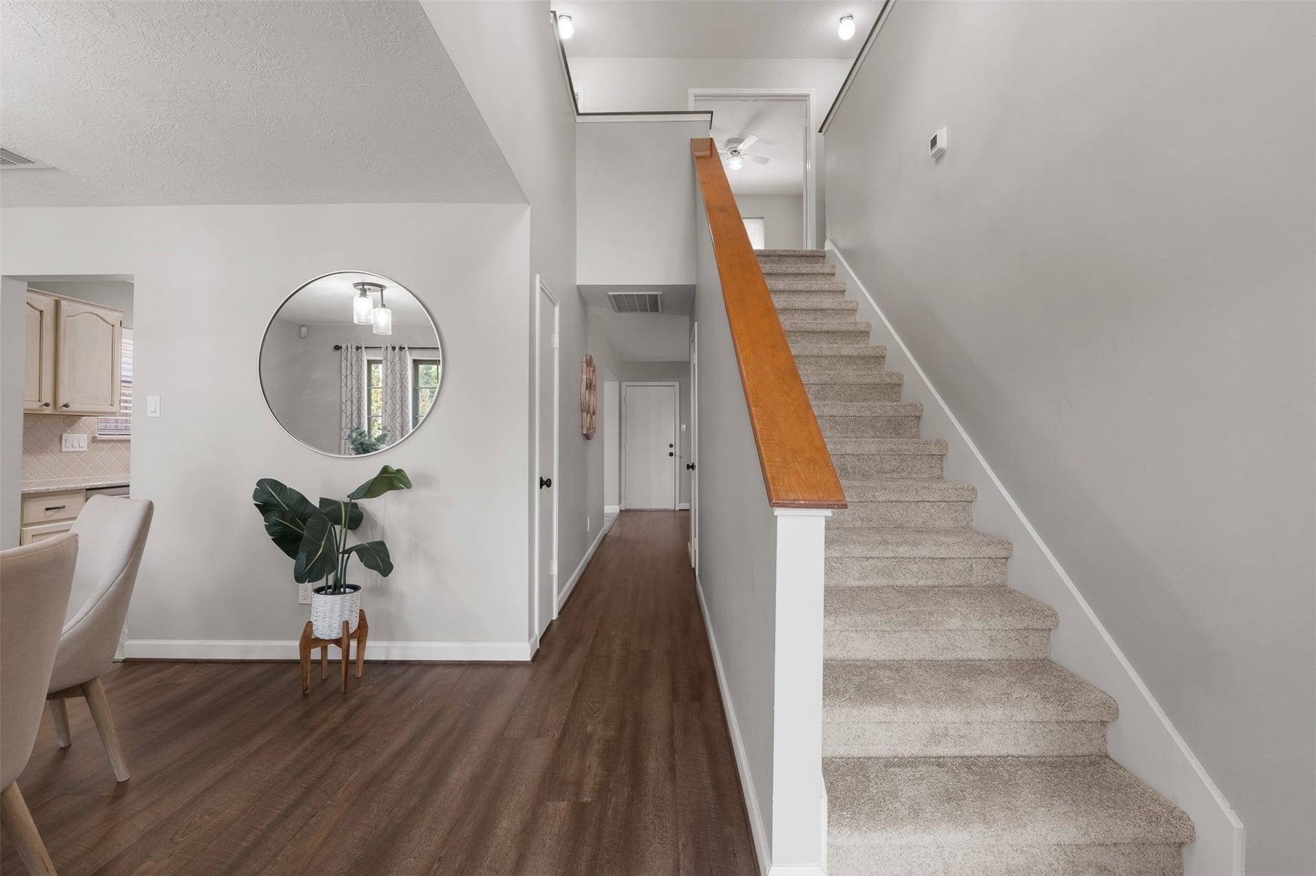 1118 Wentworth Drive, Pearland, TX 77584 Featuring plush carpeted stairs with a warm wood handrail, this soaring entry connects the lower living areas to the upper level. Rich wood-look flooring stretches past a sunlit dining nook down a central hallway, offering an open and cohesive flow.