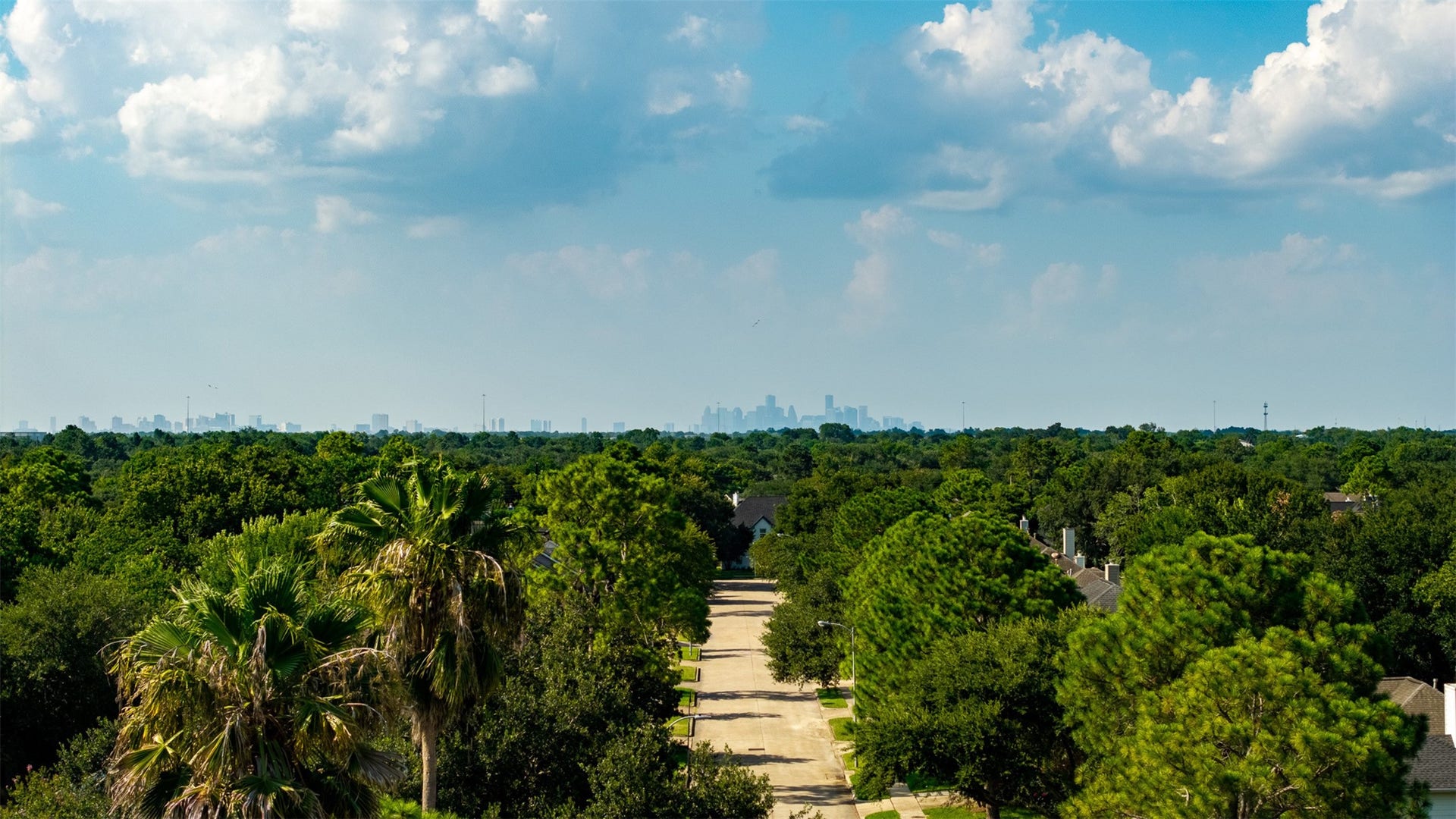 1118 Wentworth Drive, Pearland, TX 77584 Aerial perspective highlights the lush canopy of majestic trees surrounding this neighborhood with sweeping views of the distant Houston skyline. Convenient location offers an easy commute to the Medical Center along with short distance to top dining and retail options.
