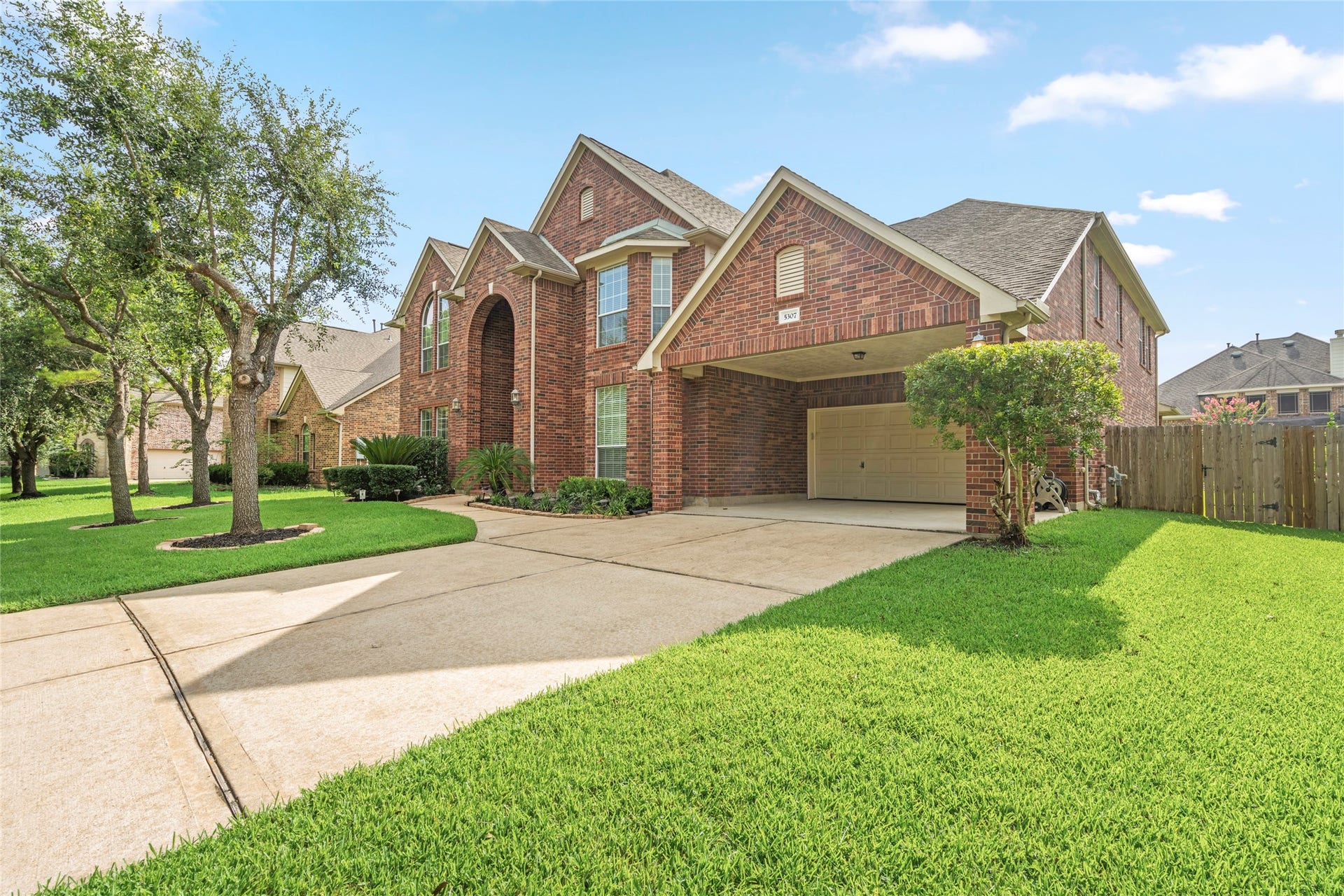 5307 Amber Sky Lane, Rosharon, TX 77583 An expansive driveway sweeps toward a rare three-car tandem garage with covered carport, offering exceptional space for vehicles, storage, or a home workshop, practicality meets curb appeal.