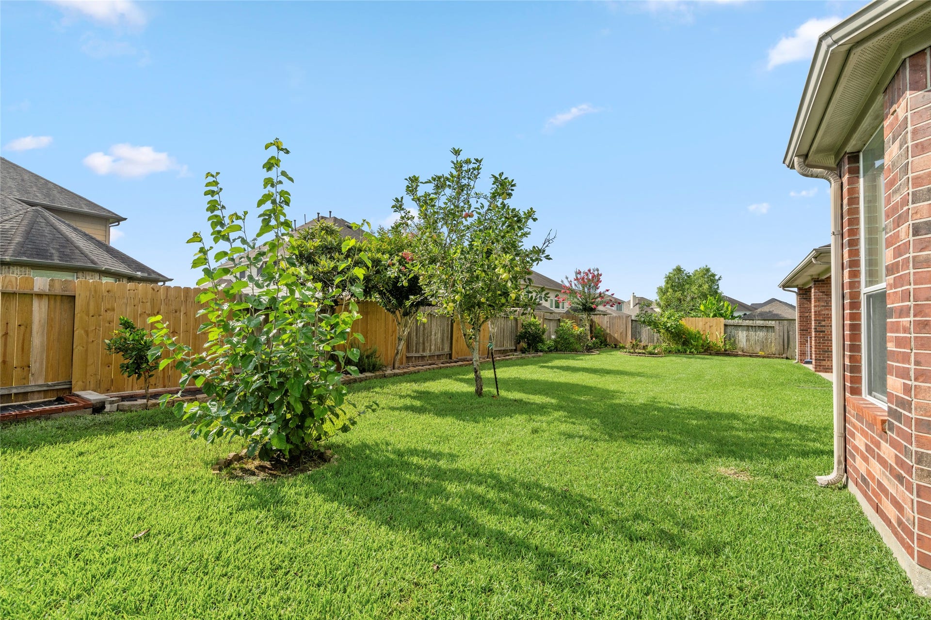 5307 Amber Sky Lane, Rosharon, TX 77583 A peaceful, fruit-tree-dotted lawn provides the ideal backdrop for outdoor gatherings, gardening, or quiet relaxation in this private retreat.