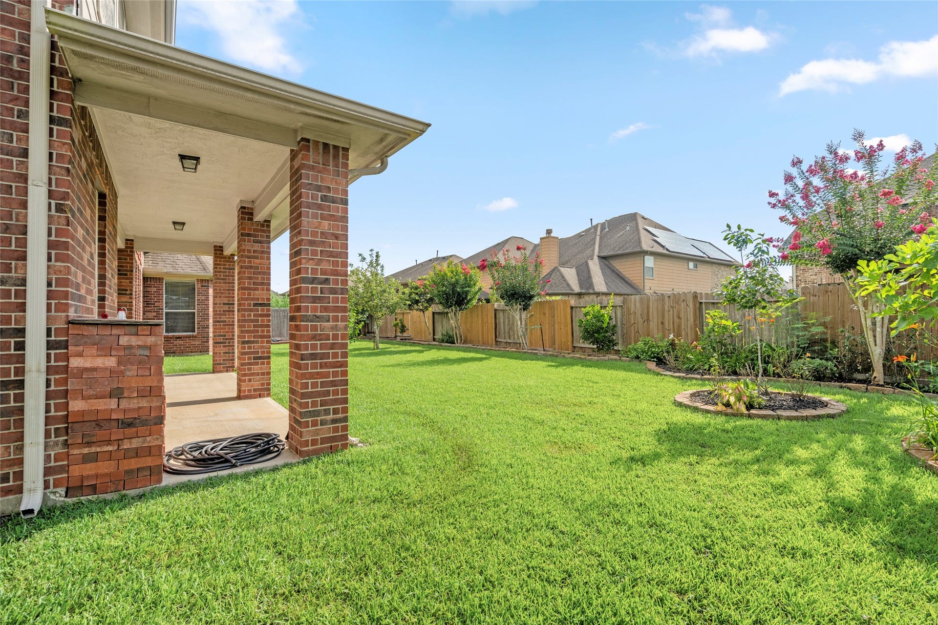 5307 Amber Sky Lane, Rosharon, TX 77583 The professionally manicured backyard unfolds with a lush green lawn and mature, fruit-bearing trees a private outdoor oasis ready to enjoy.