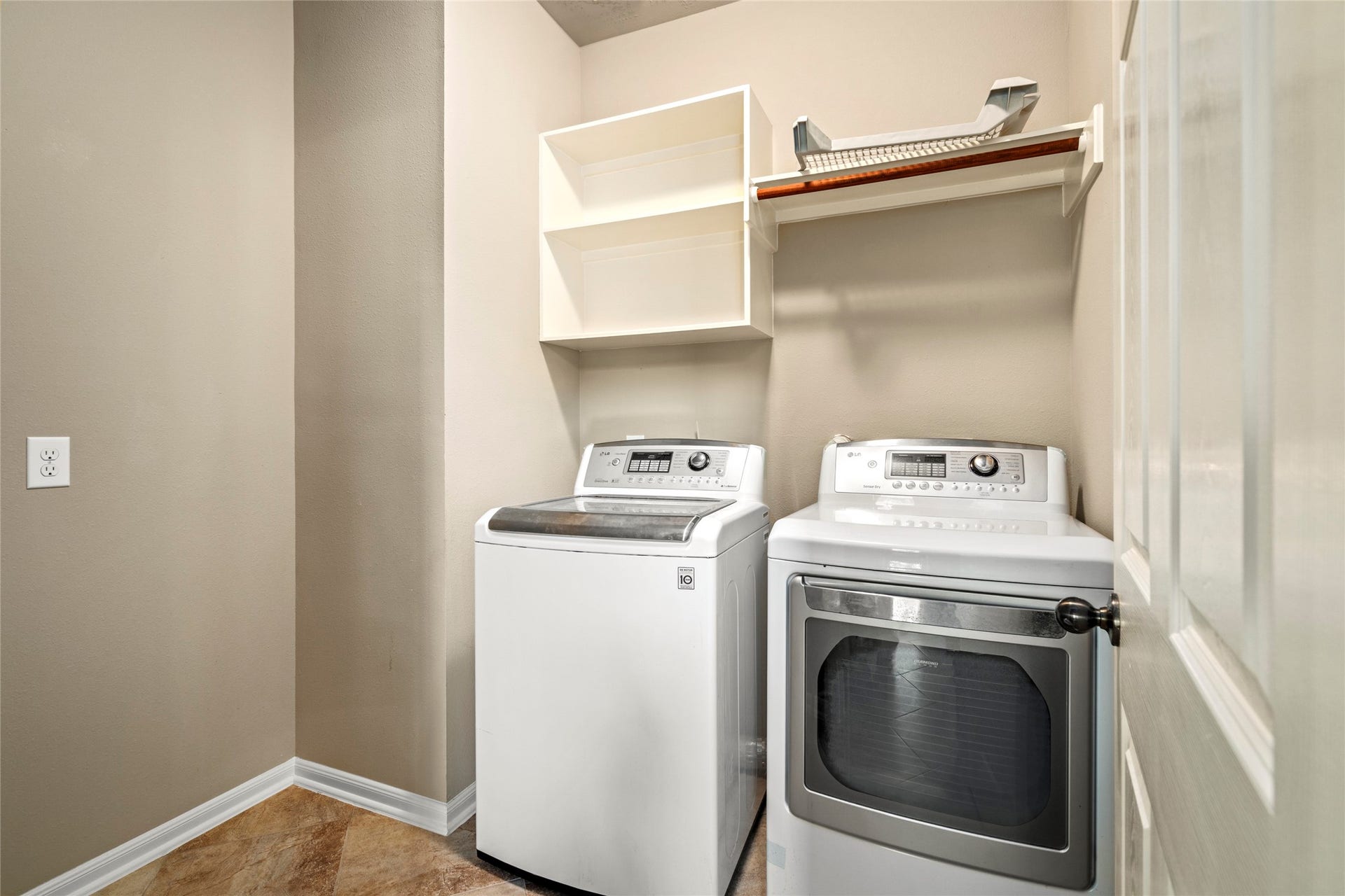 5307 Amber Sky Lane, Rosharon, TX 77583 A beautifully appointed laundry suite featuring a stainless washer and dryer that remain with the home, plus custom open shelving for effortless organization.