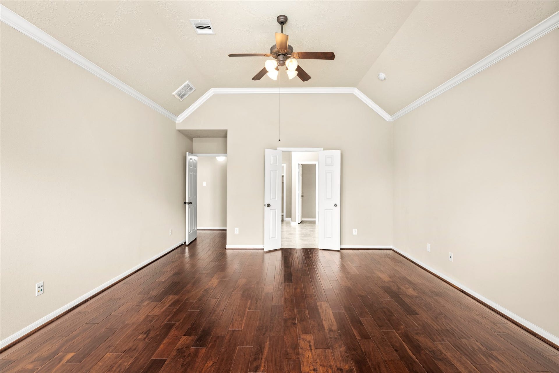 5307 Amber Sky Lane, Rosharon, TX 77583 The primary suite's wood flooring and double doors lead gracefully into the spa-inspired ensuite bath, true luxury, thoughtfully connected.
