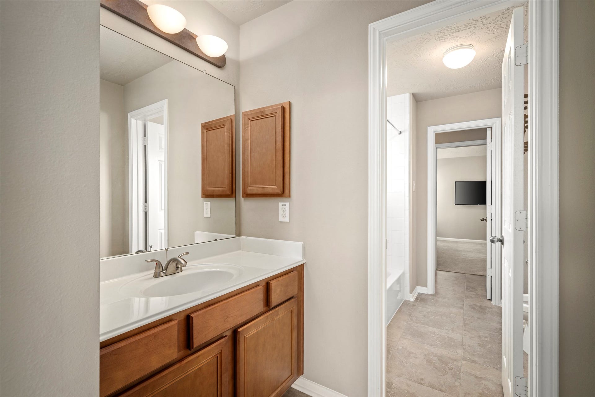 5307 Amber Sky Lane, Rosharon, TX 77583 A stylish single-sink vanity bath with a large mirror and modern lighting offers convenient access from the upstairs hallway.