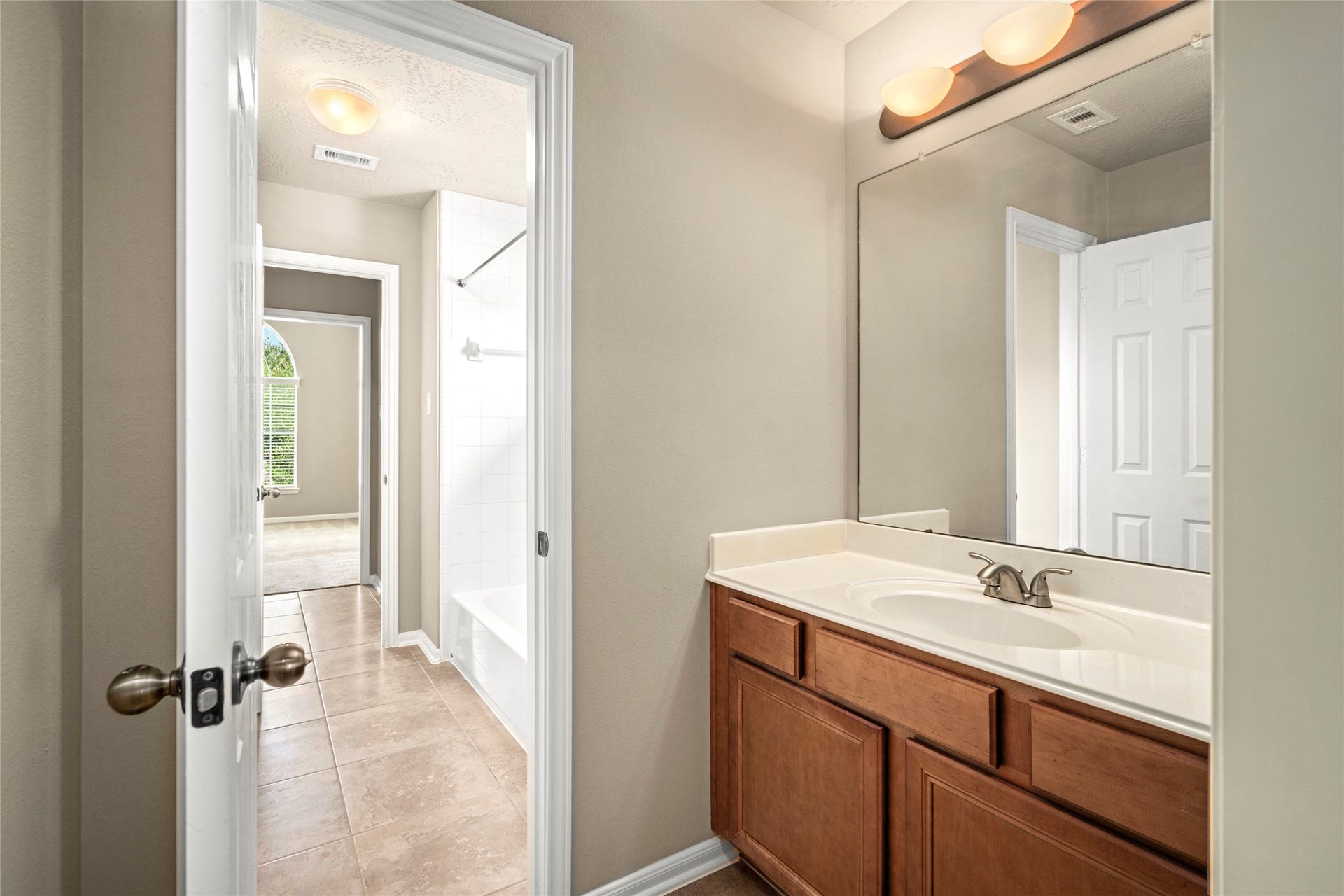 5307 Amber Sky Lane, Rosharon, TX 77583 A stylish single-sink vanity bath with a large mirror and modern lighting offers convenient access from the upstairs hallway.