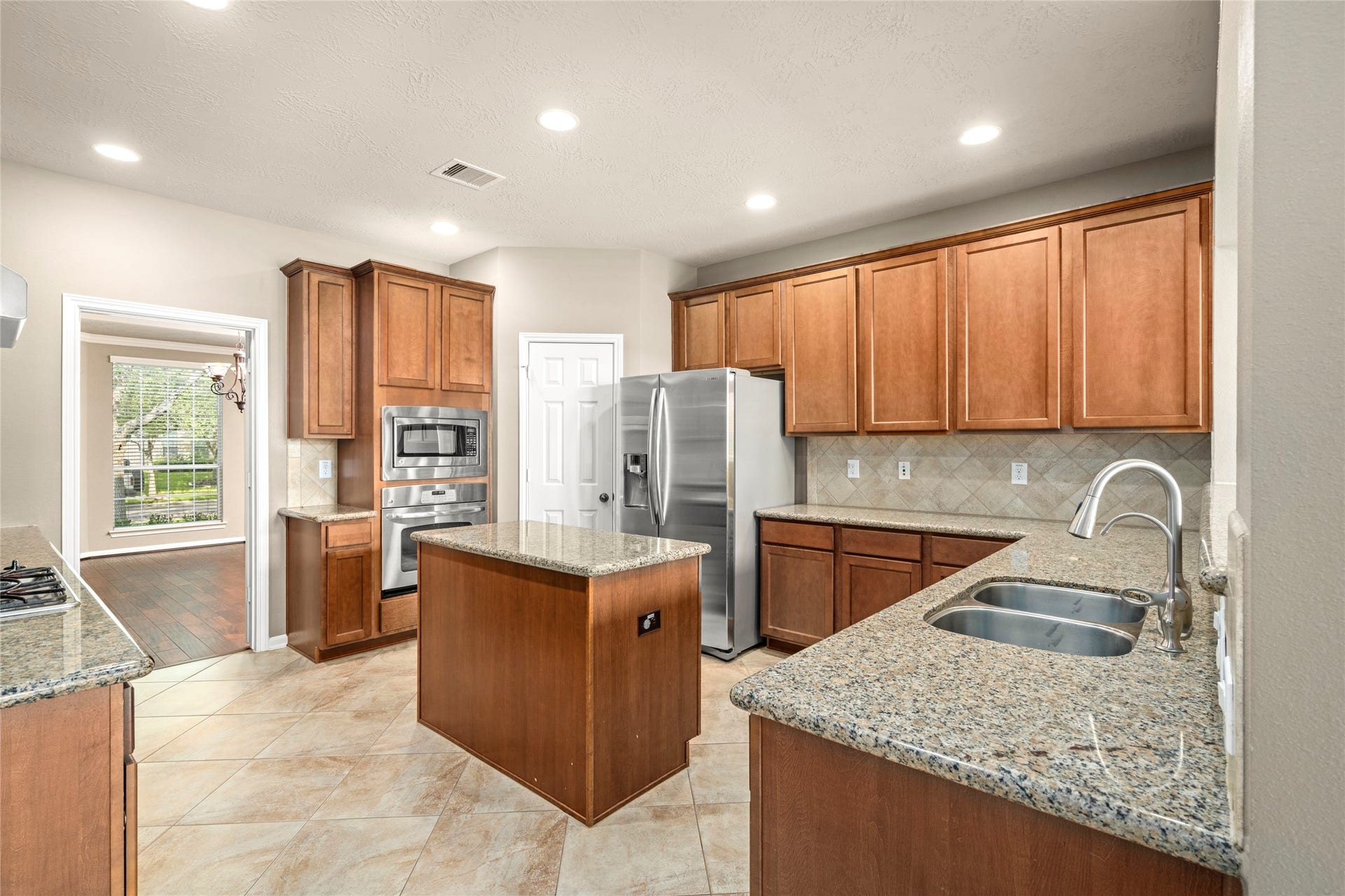 5307 Amber Sky Lane, Rosharon, TX 77583 The chef's kitchen impresseswith granite countertops, a generous island wired for convenience, gas cooktop, built-in microwave, and a refrigerator that stays, culinary luxury at its finest.