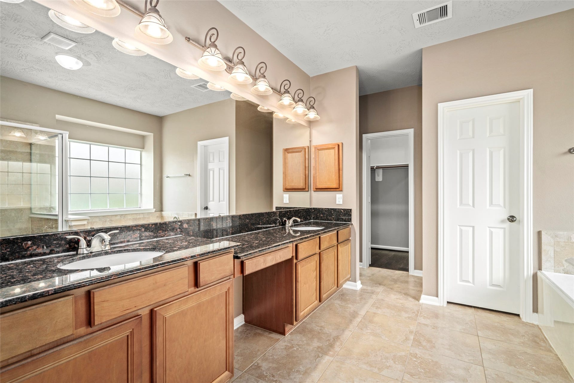 5307 Amber Sky Lane, Rosharon, TX 77583 Indulge in a double-sink vanity with granite countertops, abundant cabinetry, and designer lighting, a luxurious retreat designed for daily indulgence.
