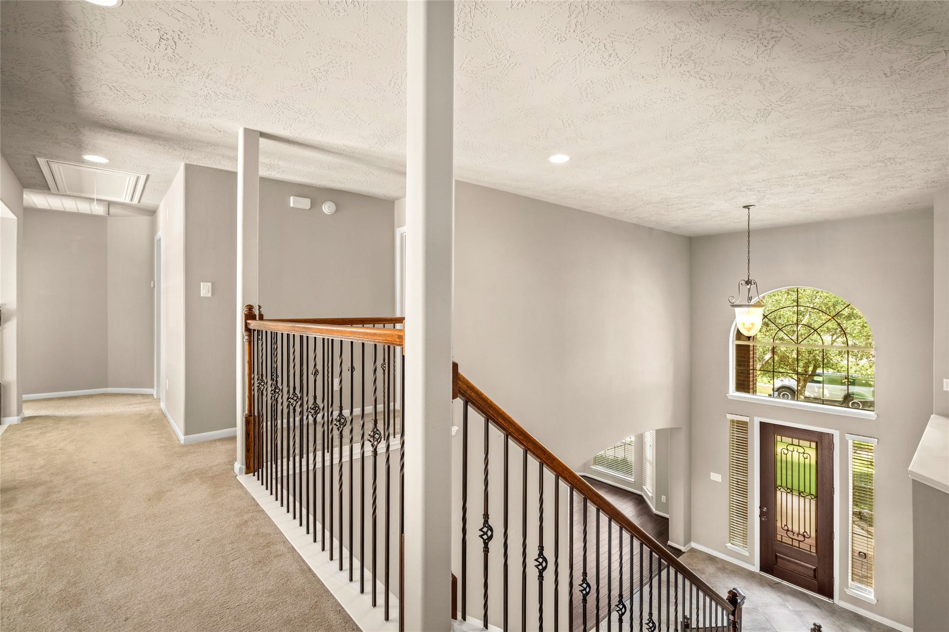 5307 Amber Sky Lane, Rosharon, TX 77583 A sleek metal-and-wood railing frames this bright open hallway overlooking the dramatic two-story living area below, an architectural highlight as you make your way to the upstairs retreats.